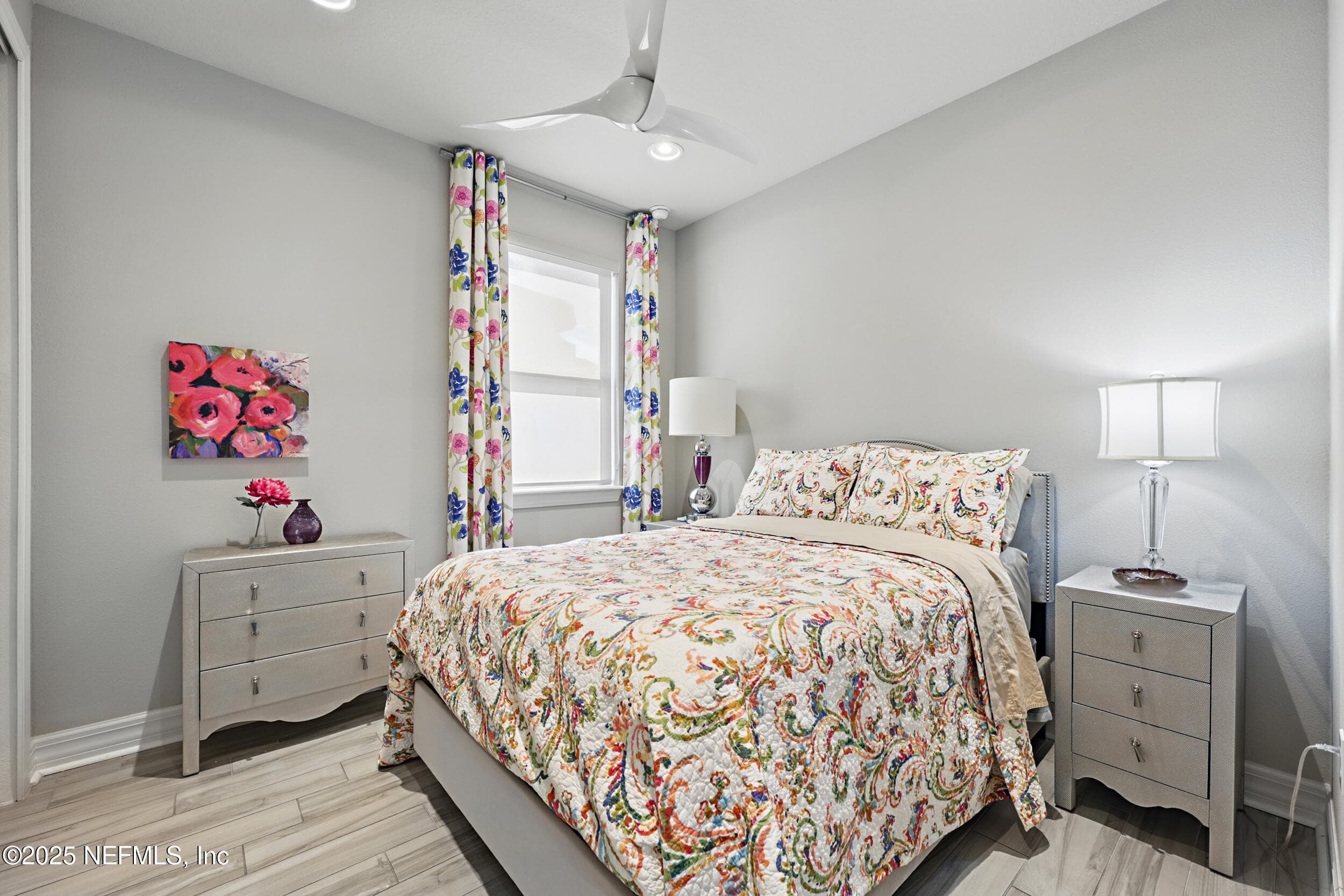 Second bedroom — First-floor guest bedroom with wood-look tile flooring, modern three-blade ceiling fan, recessed lighting, and window with roller shade and custom curtain panels. — 92 CANOPY OAK Lane, Ponte Vedra, FL 32081