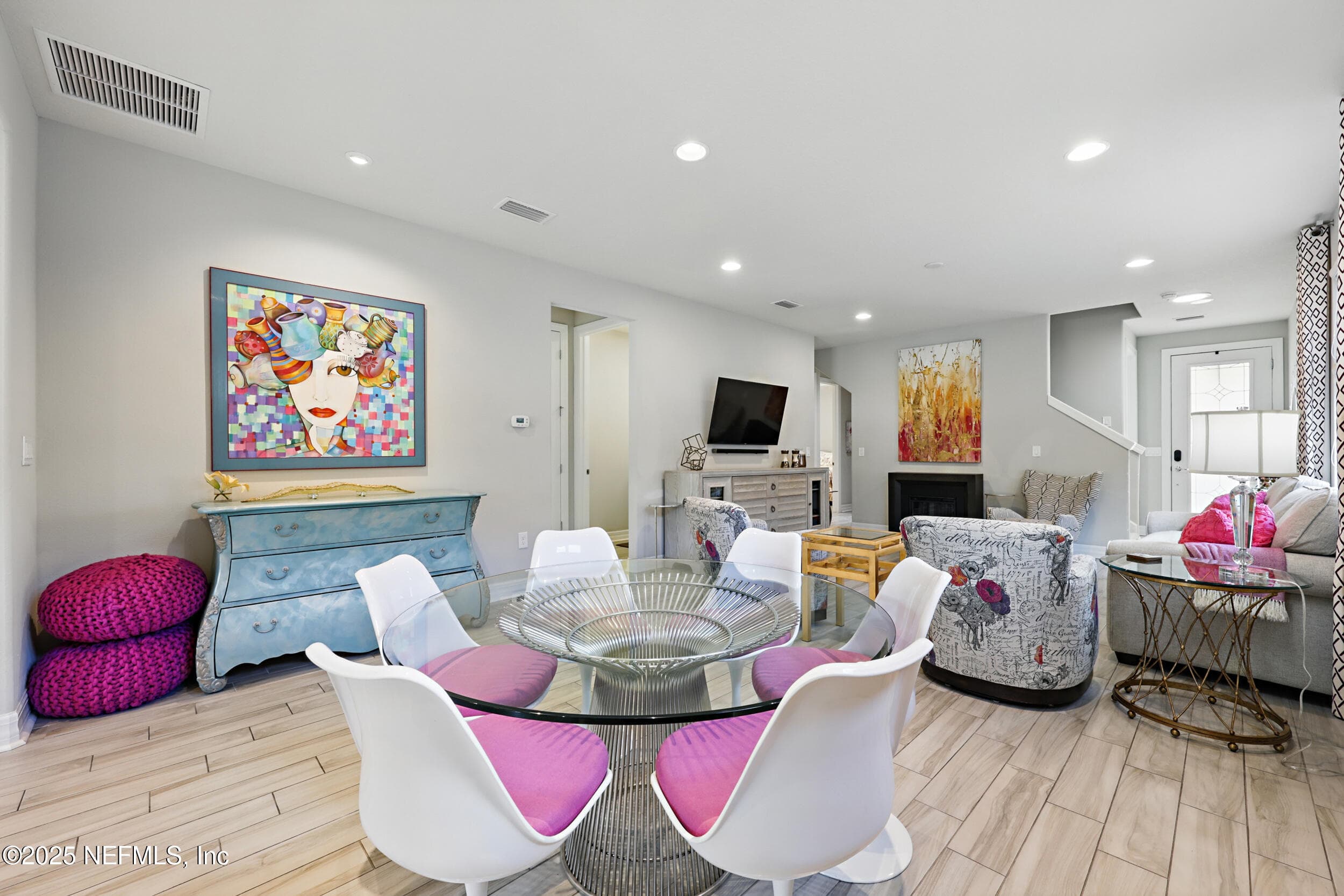Dining area (alternate angle) — Open dining area with sightlines to the living room, electric fireplace, staircase, and front entry. Wood-look tile flooring runs continuously through the main level. — 92 CANOPY OAK Lane, Ponte Vedra, FL 32081