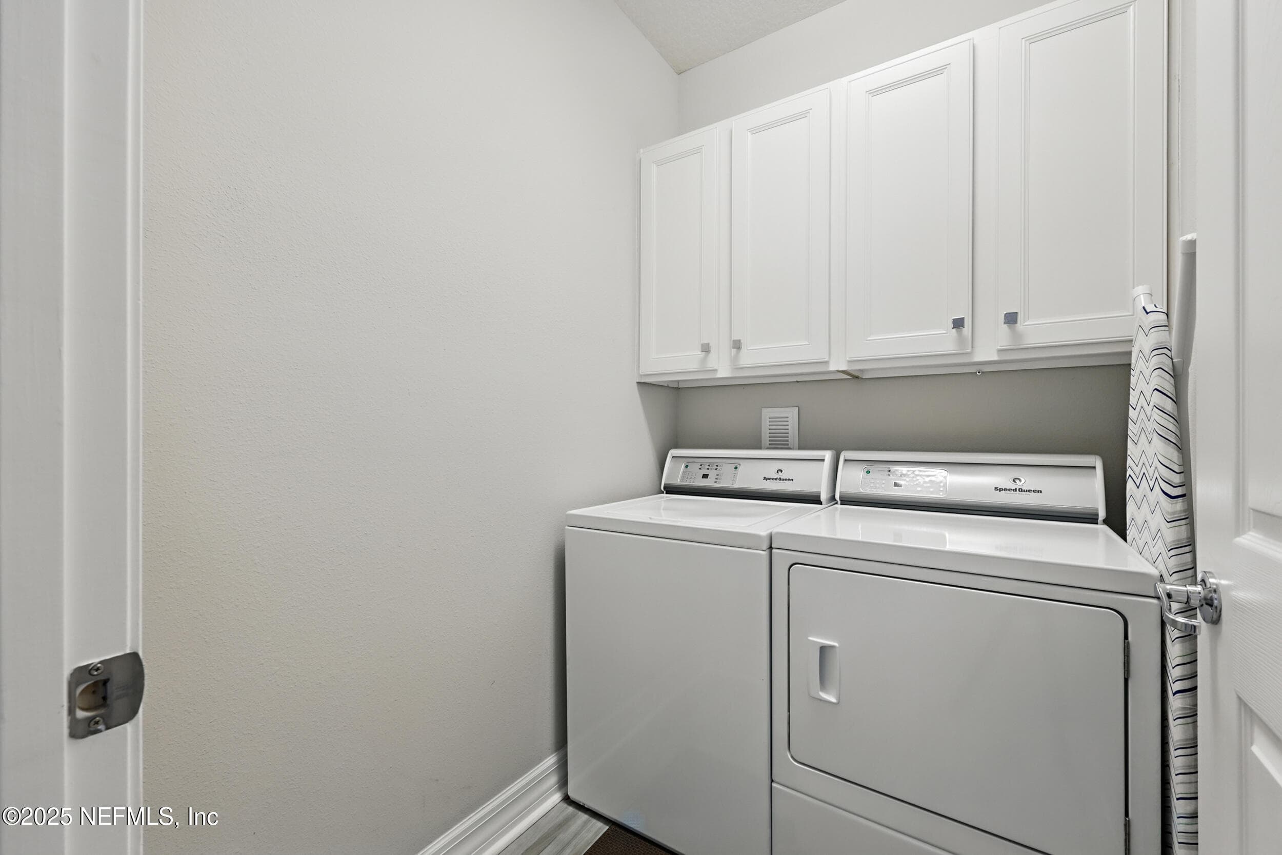 Laundry room — Dedicated laundry room with Speed Queen side-by-side washer and dryer, white shaker upper cabinetry for storage, and easy first-floor access. — 92 CANOPY OAK Lane, Ponte Vedra, FL 32081