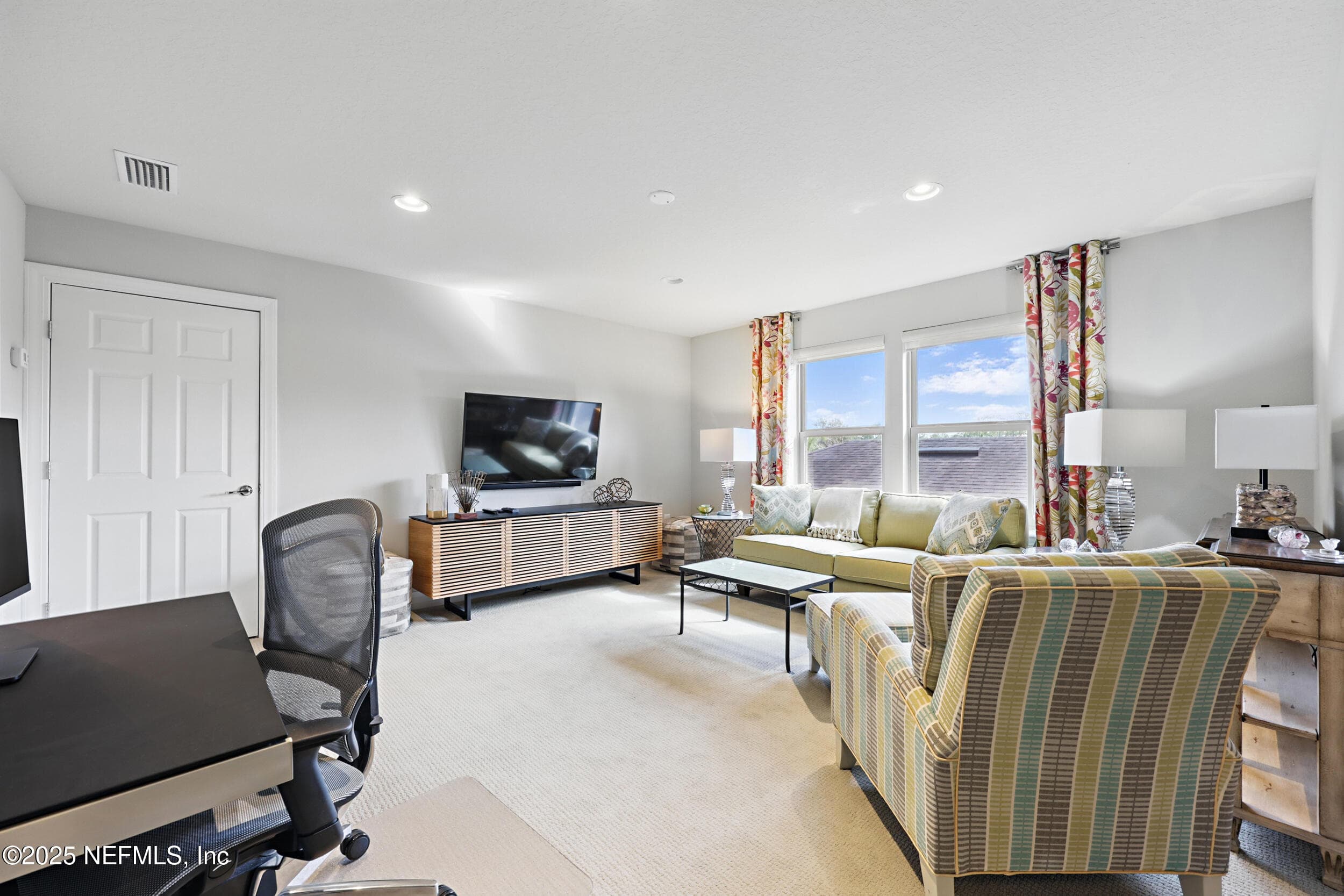 Second-floor loft — Spacious second-floor loft with carpet flooring, recessed lighting, multiple windows with custom curtain panels and roller shades, closet storage, and room for a media area and home office workspace. — 92 CANOPY OAK Lane, Ponte Vedra, FL 32081