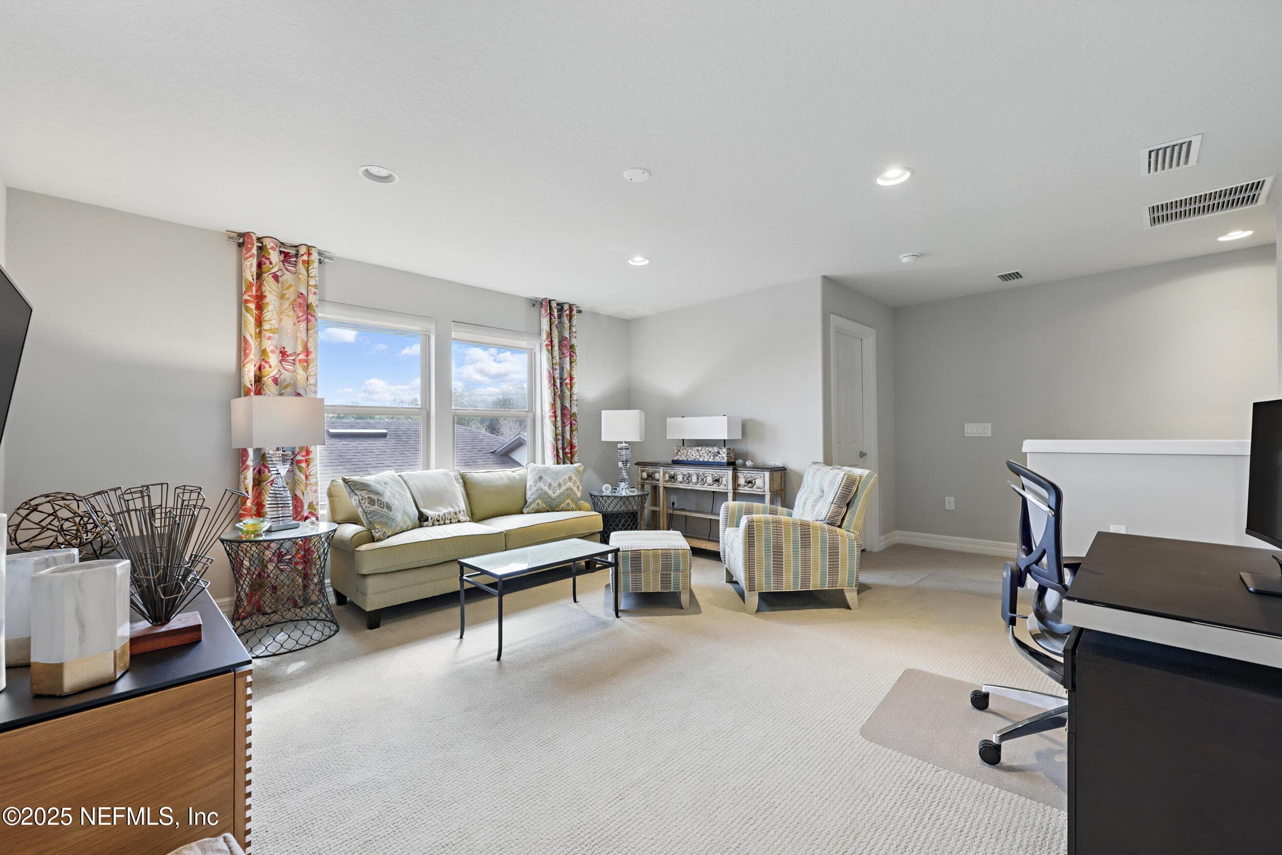 Second-floor loft (alternate angle) — Loft with large windows for natural light, carpet flooring, recessed lighting, custom curtain panels, closet, and open staircase access. Versatile space for a home office, media room, or recreation area. — 92 CANOPY OAK Lane, Ponte Vedra, FL 32081