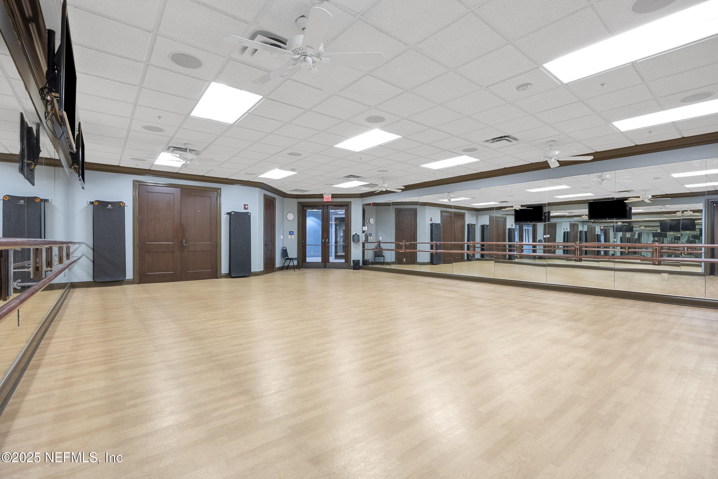 Anastasia Clubhouse movement studio — Movement studio inside the Anastasia Clubhouse with hardwood sprung flooring, full-length mirrored walls, ballet barre, ceiling fans, wall-mounted TVs, and sound system for group fitness classes, yoga, and dance. — 92 CANOPY OAK Lane, Ponte Vedra, FL 32081