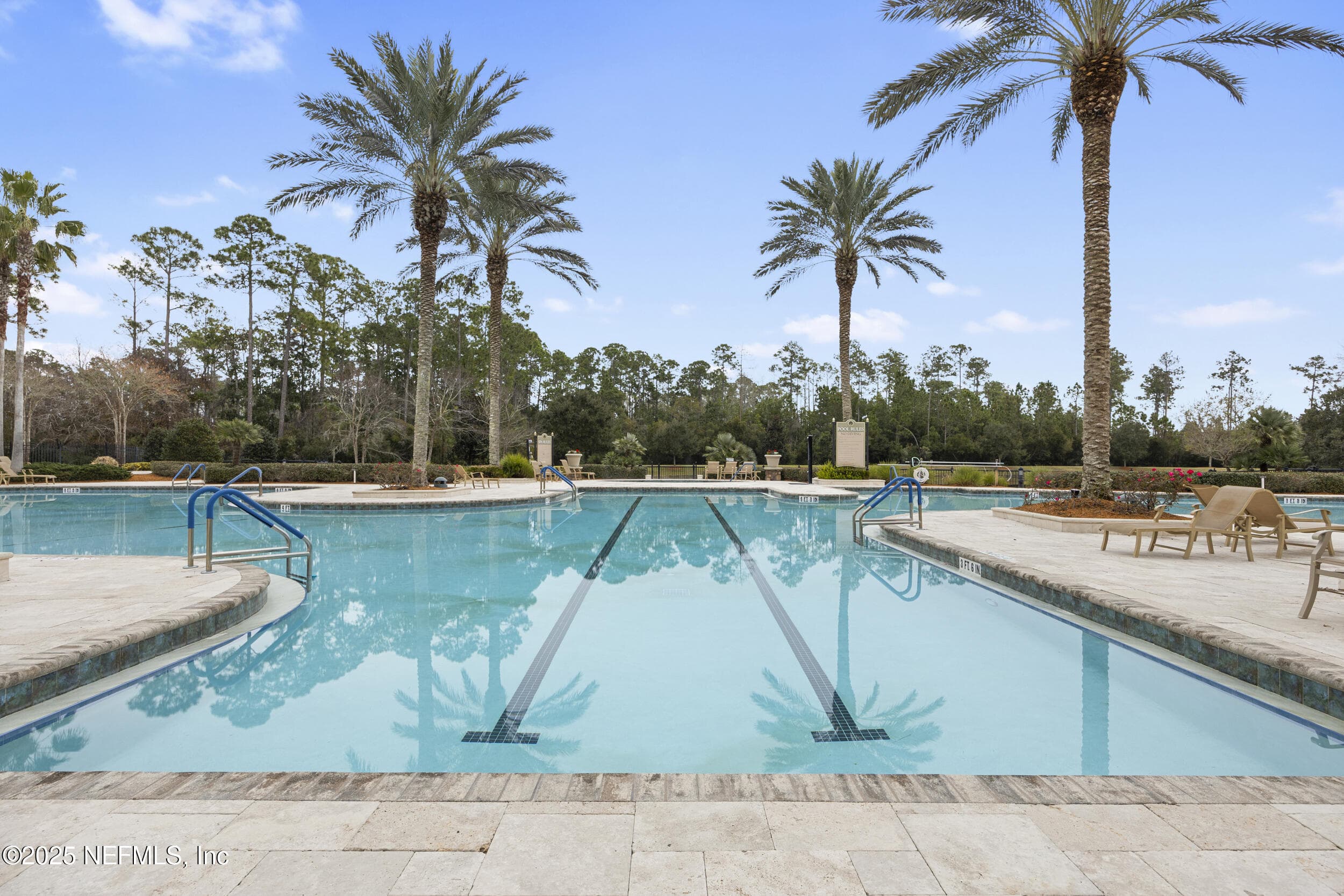 Del Webb Ponte Vedra outdoor pool — Resort-style outdoor pool with travertine paver deck, lap lanes, handrail entries, palm tree landscaping, and preserve views at the Anastasia Clubhouse in Del Webb Ponte Vedra. — 92 CANOPY OAK Lane, Ponte Vedra, FL 32081