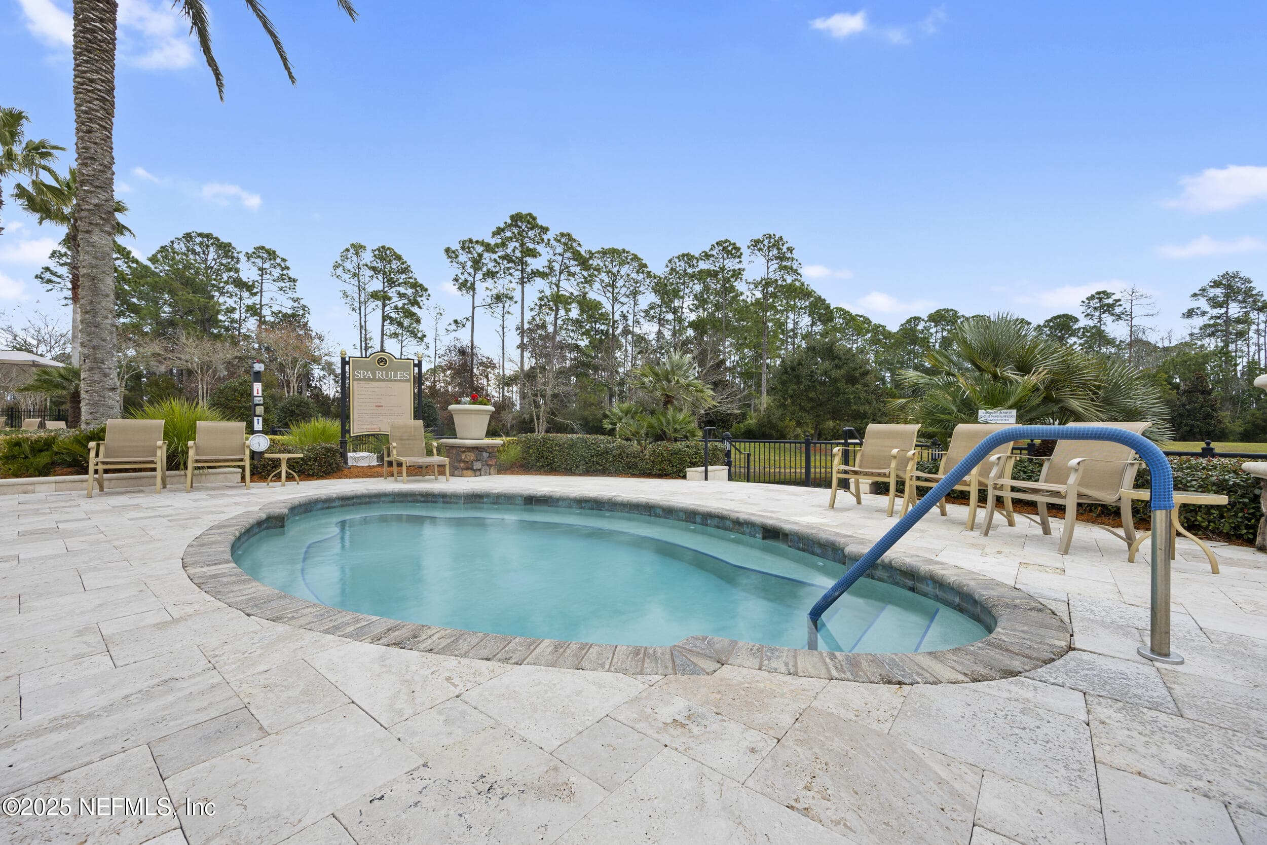 Del Webb Ponte Vedra outdoor spa — Outdoor heated spa with travertine paver surround, handrail entry, lounge chairs, palm trees, and preserve backdrop adjacent to the outdoor pool at Del Webb Ponte Vedra. — 92 CANOPY OAK Lane, Ponte Vedra, FL 32081