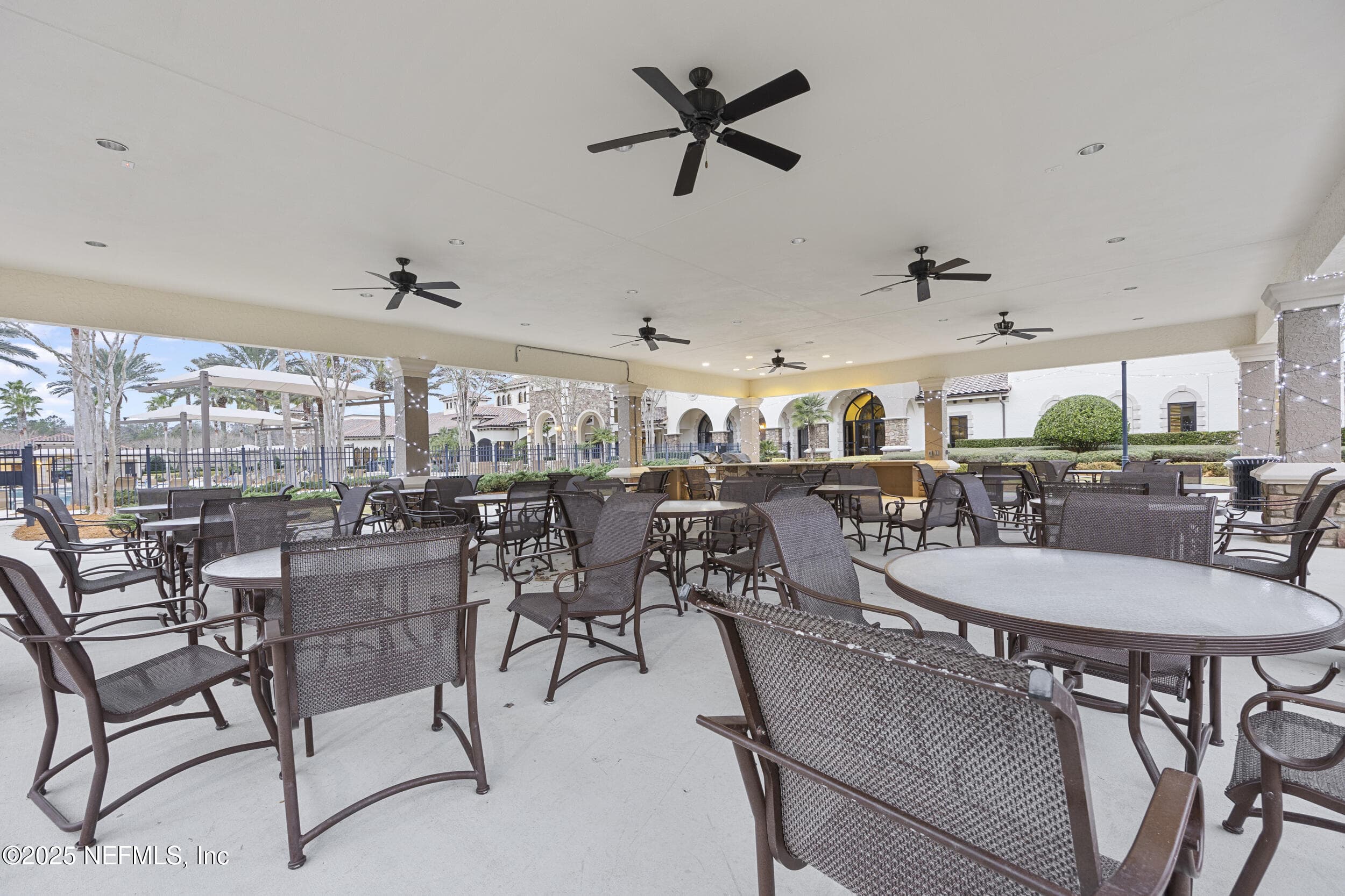 Del Webb Ponte Vedra outdoor cabana — Covered outdoor cabana pavilion with ceiling fans, dining tables and chairs, string lights, and views of the pool area and Anastasia Clubhouse at Del Webb Ponte Vedra. — 92 CANOPY OAK Lane, Ponte Vedra, FL 32081