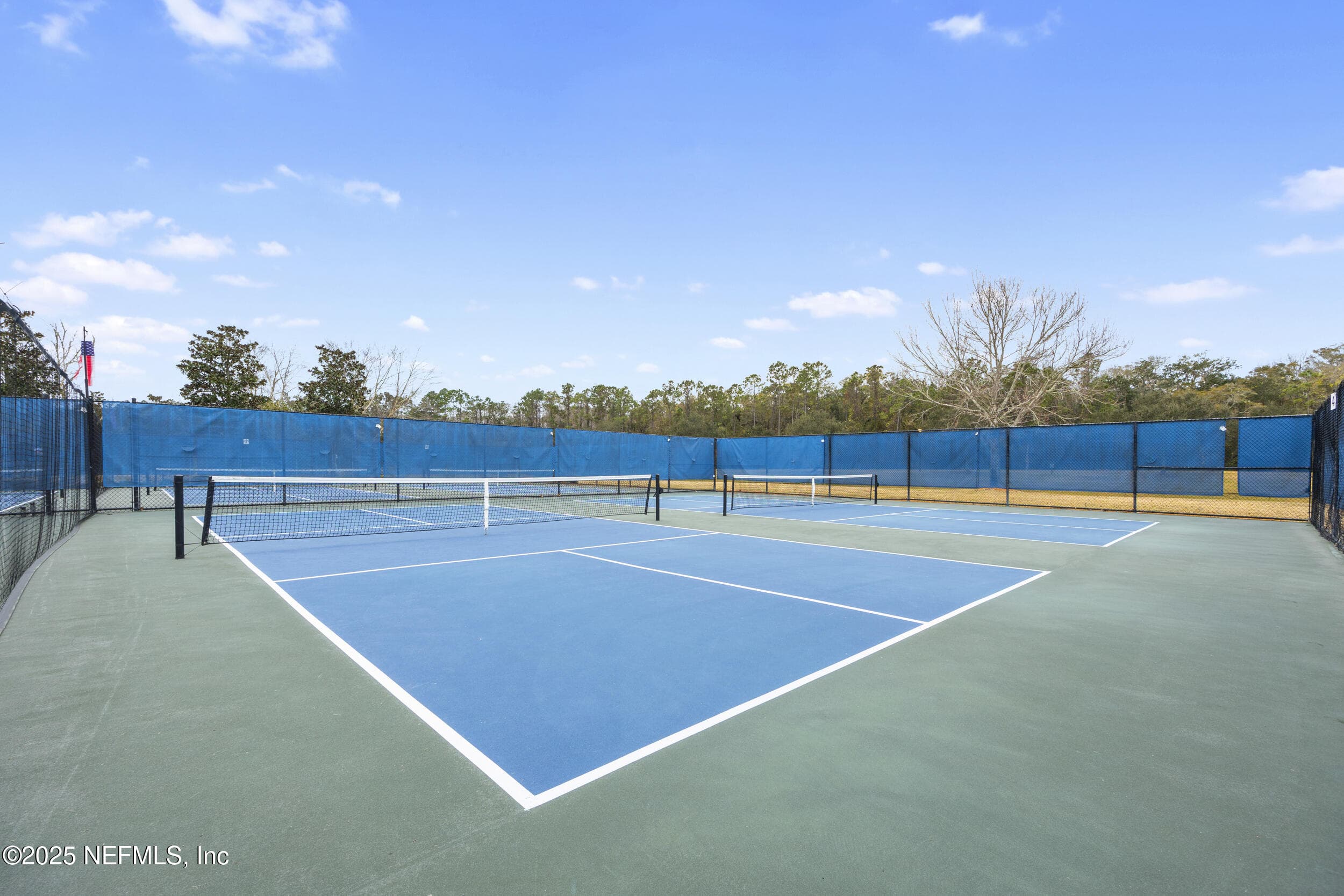 Del Webb pickleball courts — Multiple dedicated pickleball courts with blue hard-court playing surfaces, windscreens, perimeter fencing. — 92 CANOPY OAK Lane, Ponte Vedra, FL 32081