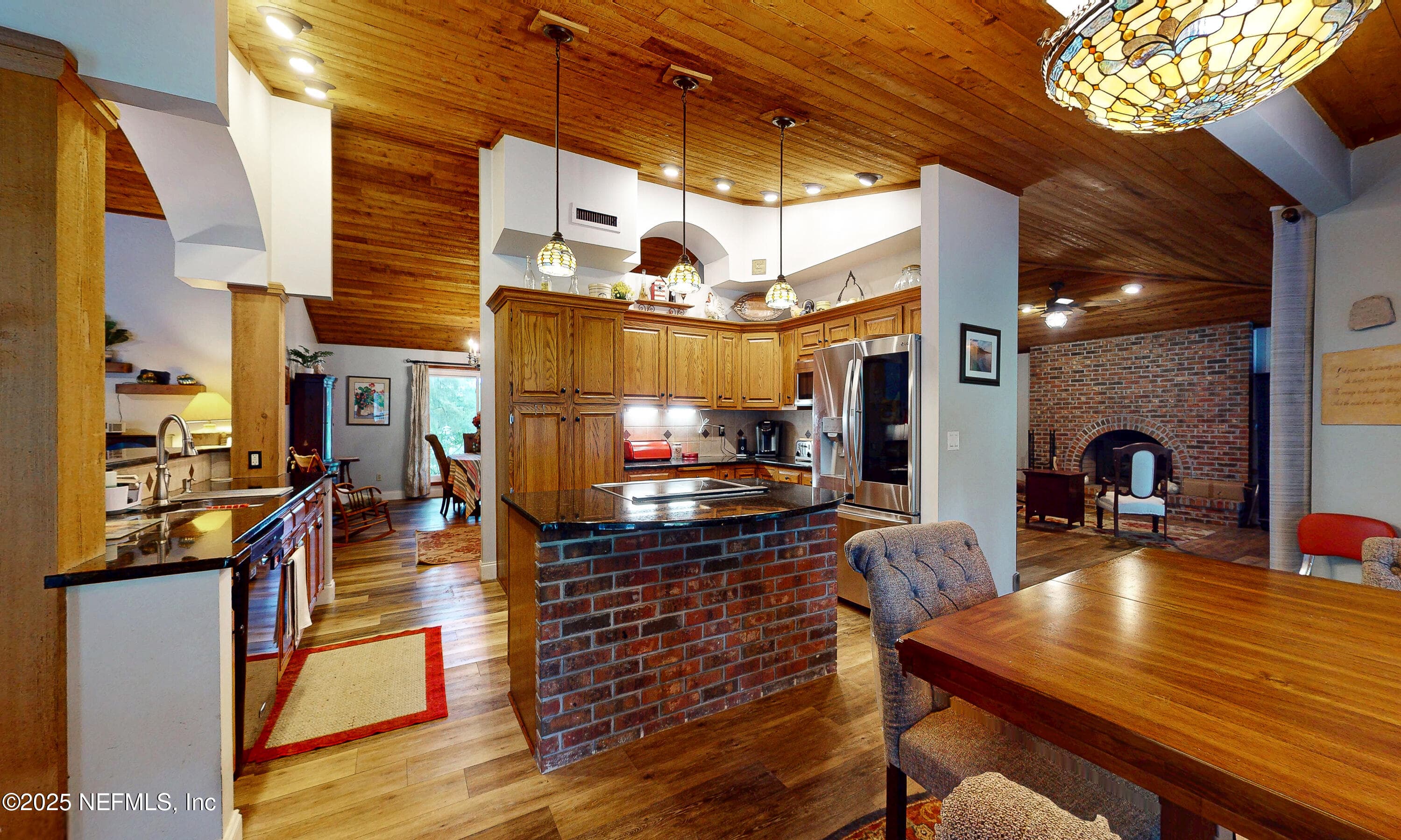 Kitchen island with brick accent and granite countertops — 2860 RAVINES Road, Middleburg, FL 32068