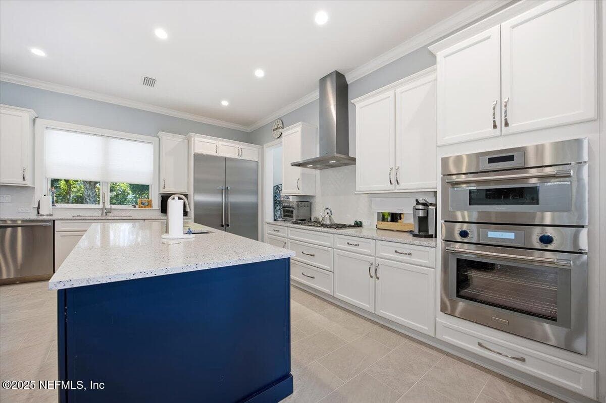Navy large island with sink! Countertops are quartz,colors from ground up glass at the bottom of the ocean. So beautiful. All top of the line Thermador appliances. — 4 SUMMER Court, Jacksonville Beach, FL 32250