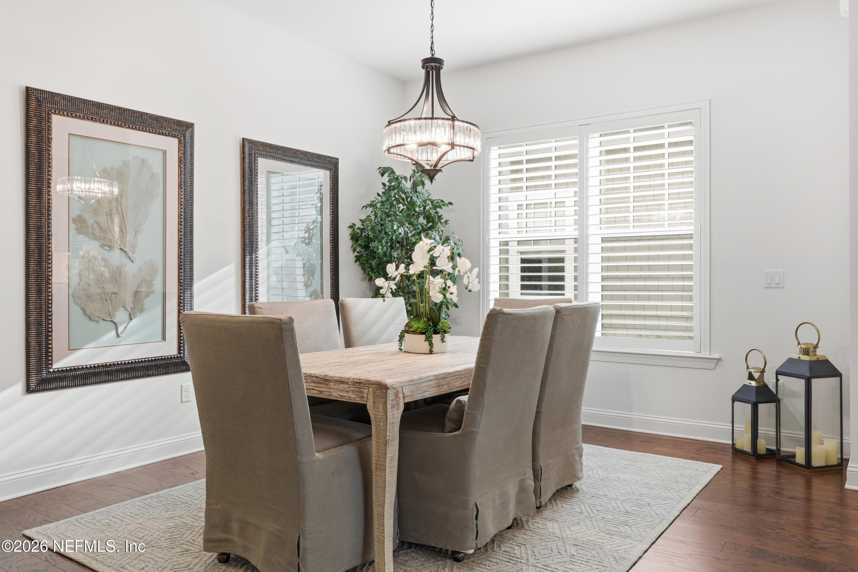 Dining space with plantation shutters, neutral finishes, and modern chandelier lighting. — 568 TIMBER BRIDGE Lane, Atlantic Beach, FL 32233