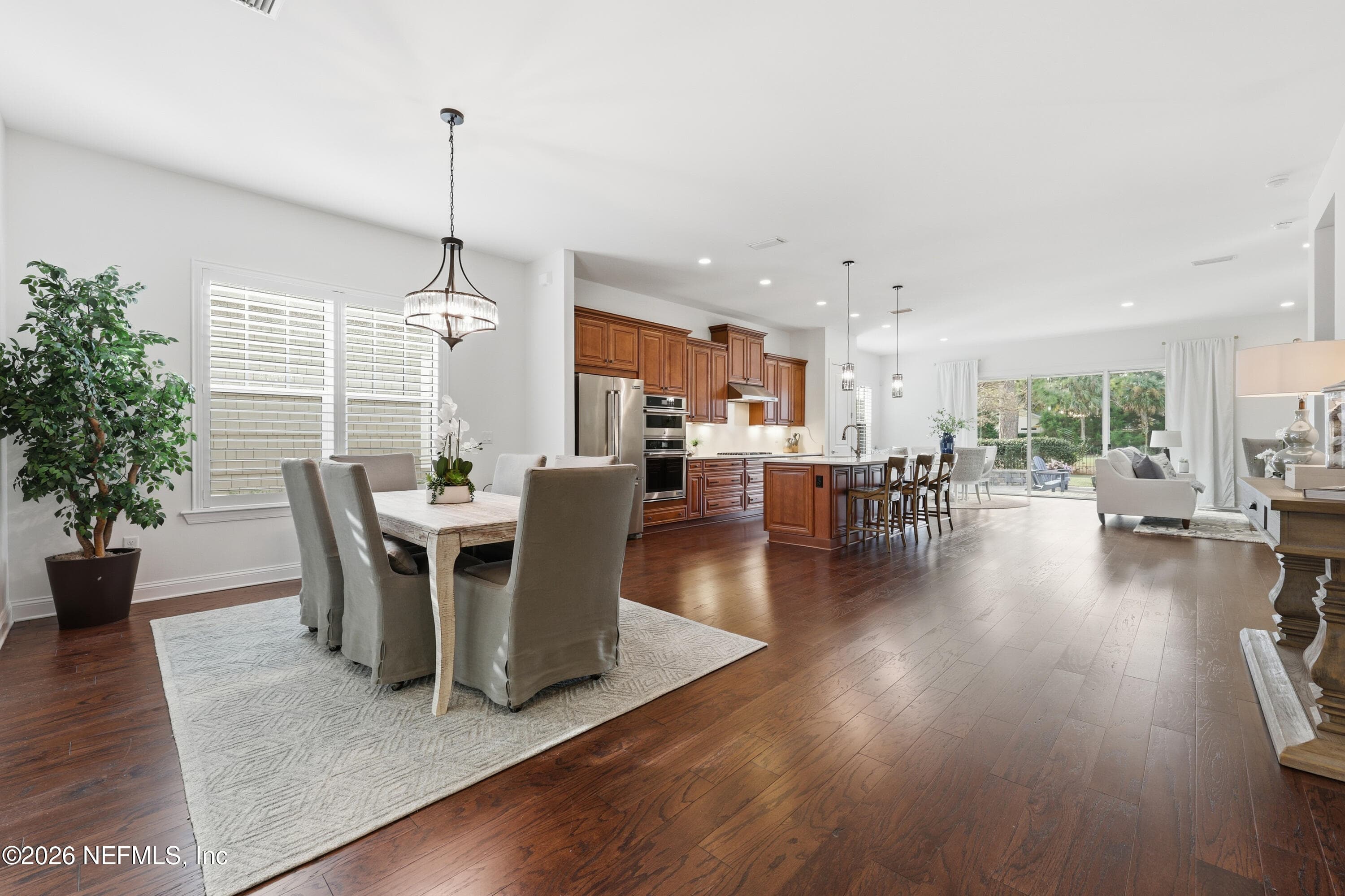 Open-plan living and dining flowing into kitchen with hardwood floors and recessed lighting. — 568 TIMBER BRIDGE Lane, Atlantic Beach, FL 32233