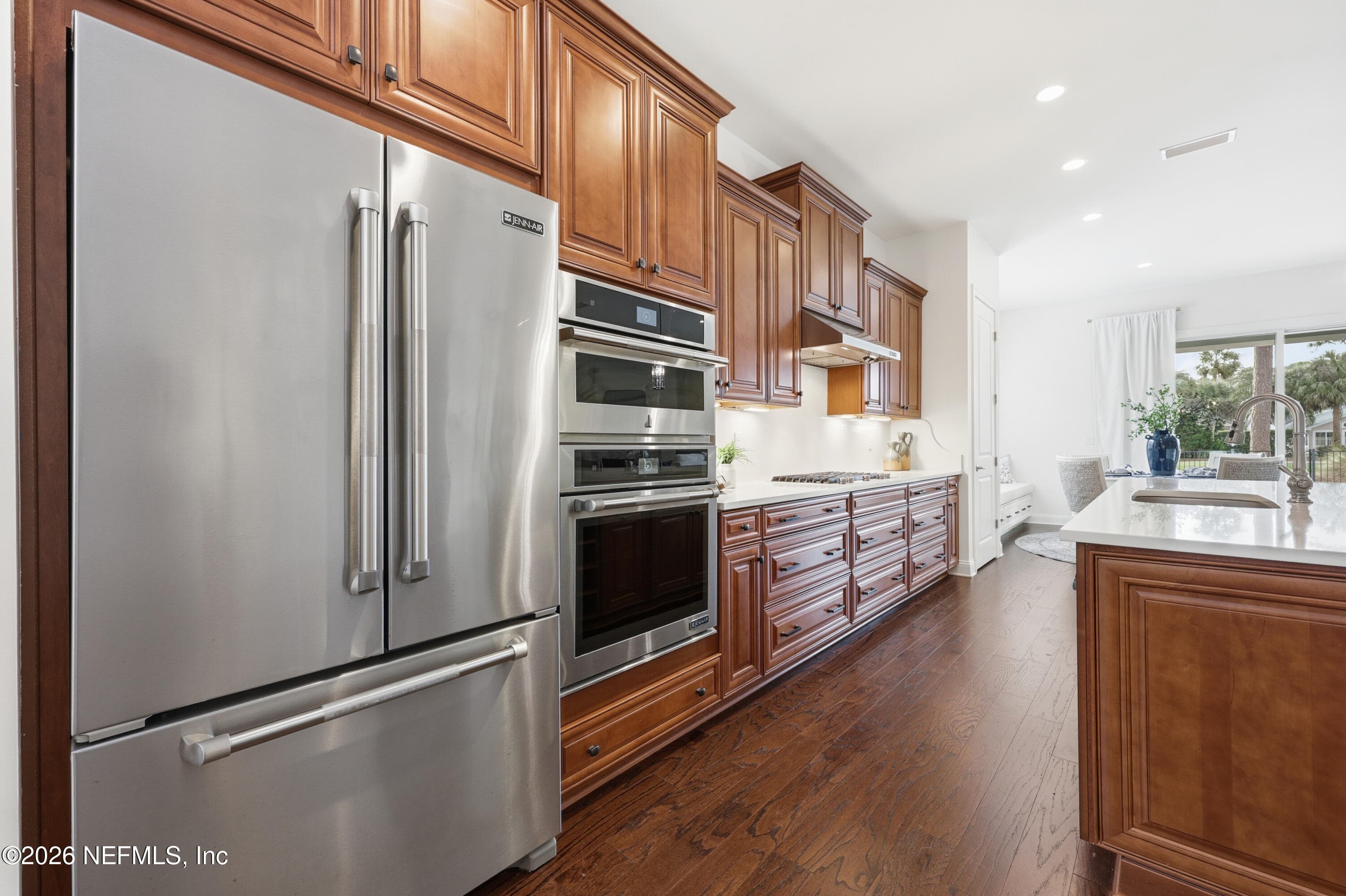 Stainless refrigerator and wall oven stack set within wood cabinetry. — 568 TIMBER BRIDGE Lane, Atlantic Beach, FL 32233