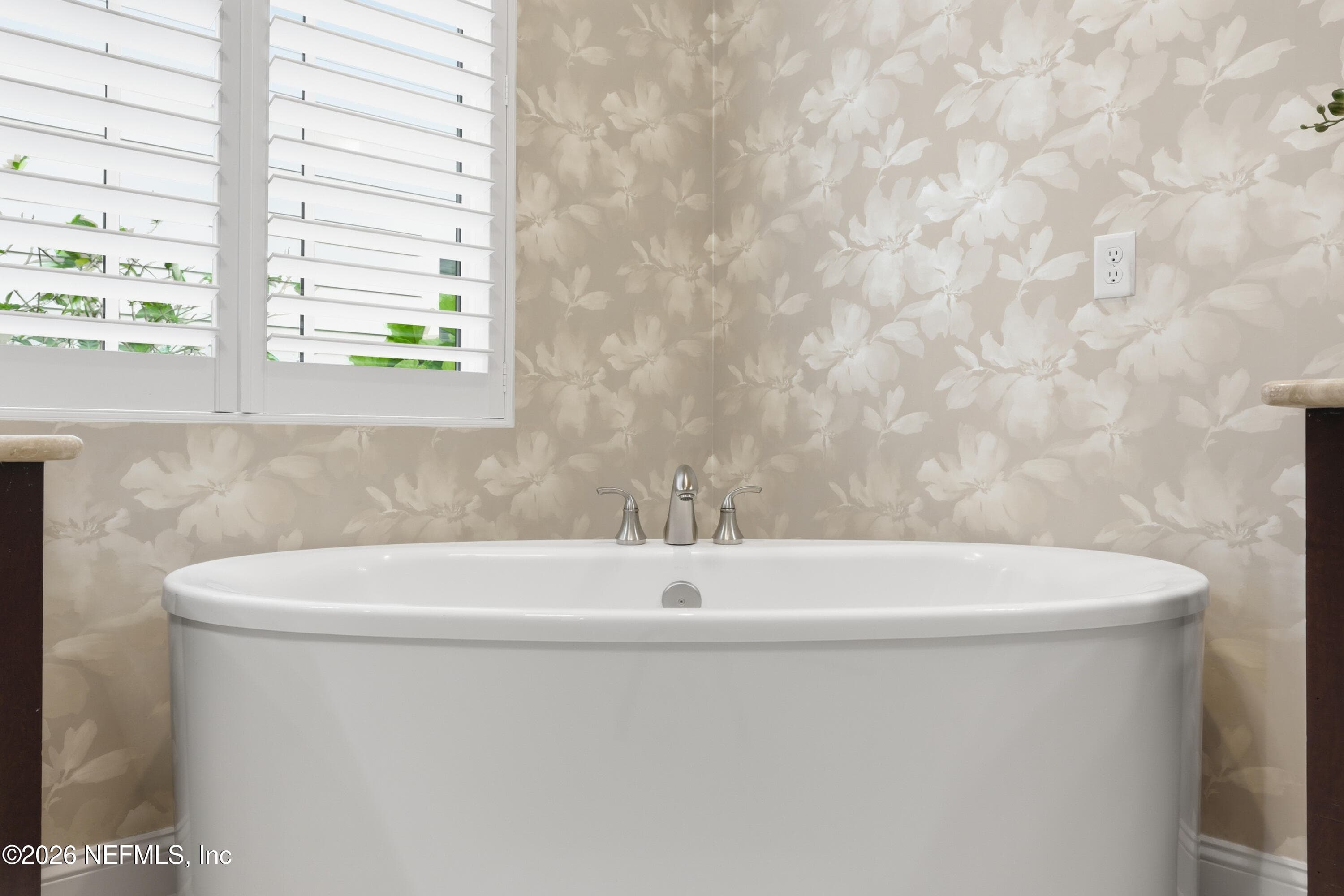 Freestanding soaking tub positioned under a window with patterned wall finish. — 568 TIMBER BRIDGE Lane, Atlantic Beach, FL 32233