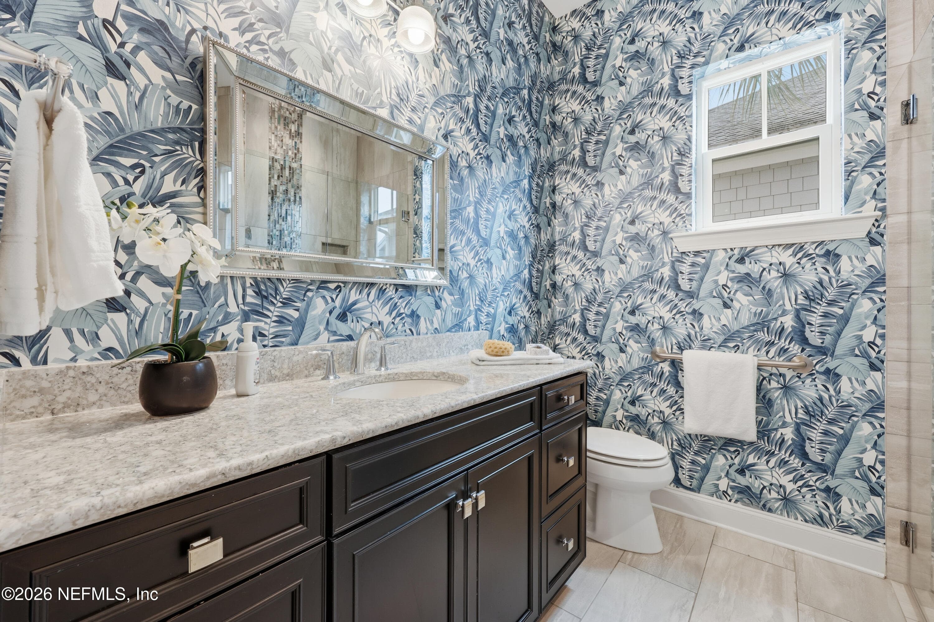 First-floor bathroom with gorgeous blue patterned wall finish, vanity, and mirror with modern lighting. — 568 TIMBER BRIDGE Lane, Atlantic Beach, FL 32233