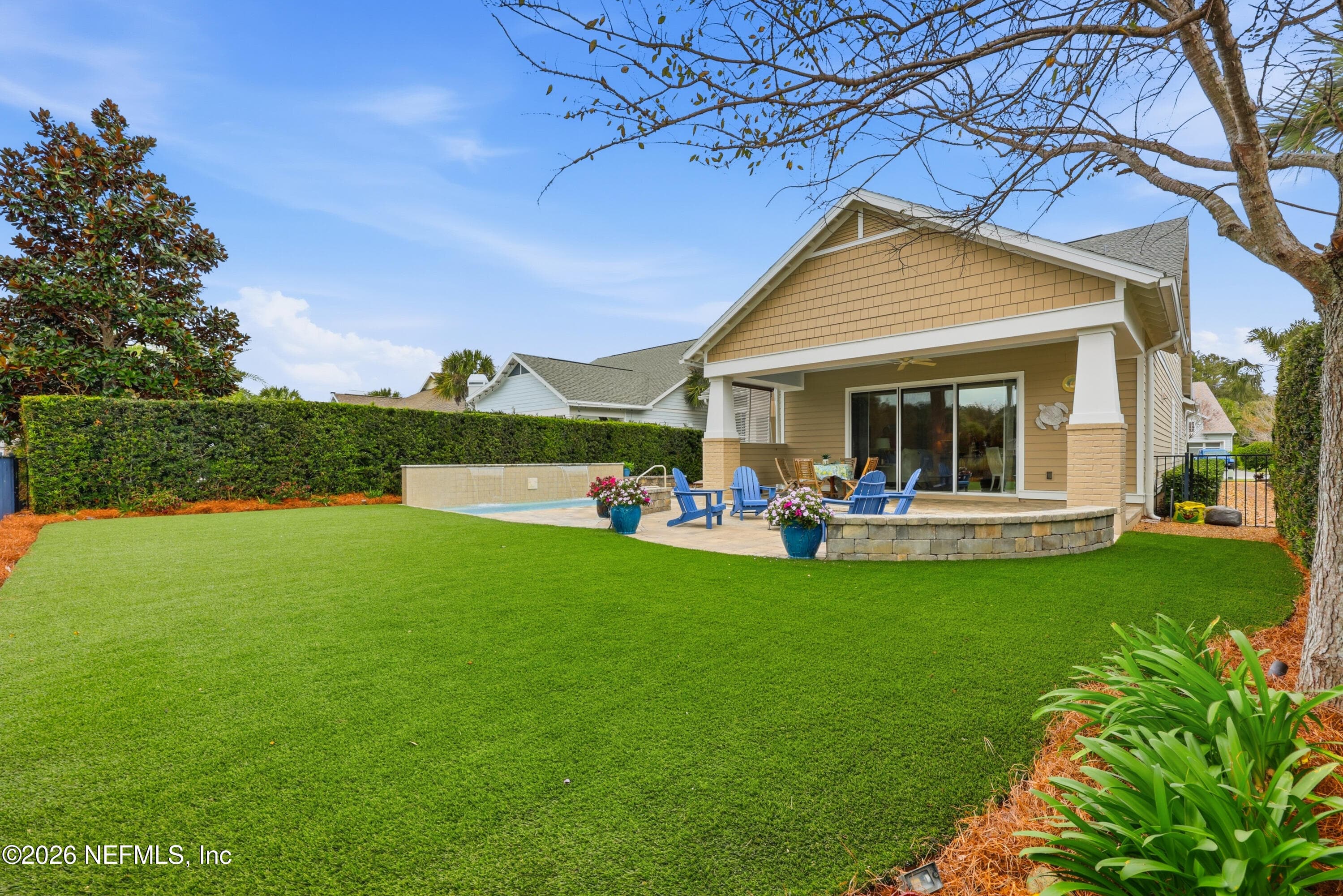 Backyard view showing expansive lawn/turf and rear covered patio. — 568 TIMBER BRIDGE Lane, Atlantic Beach, FL 32233
