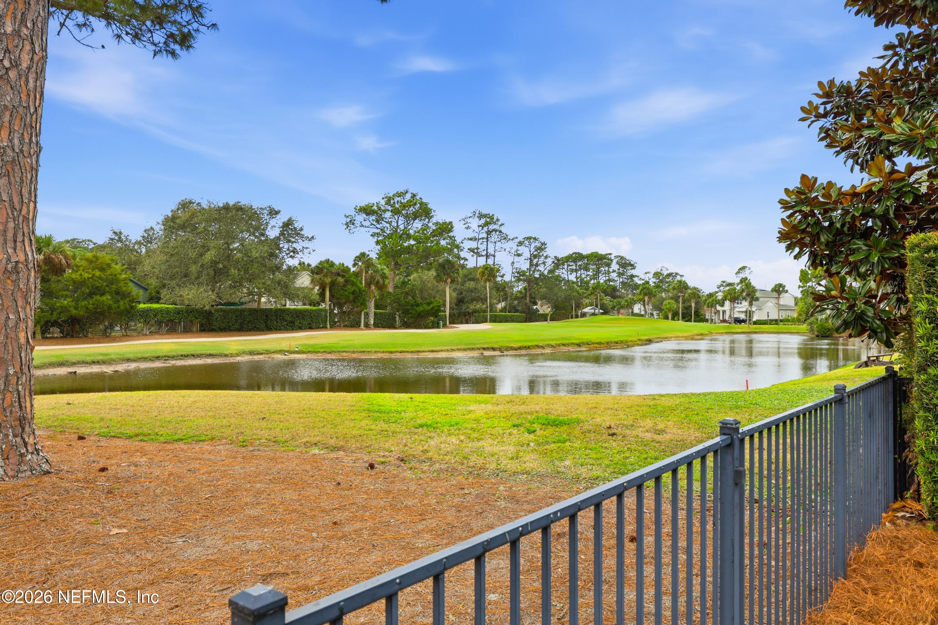 View across fencing toward water feature and golf-course greens. — 568 TIMBER BRIDGE Lane, Atlantic Beach, FL 32233