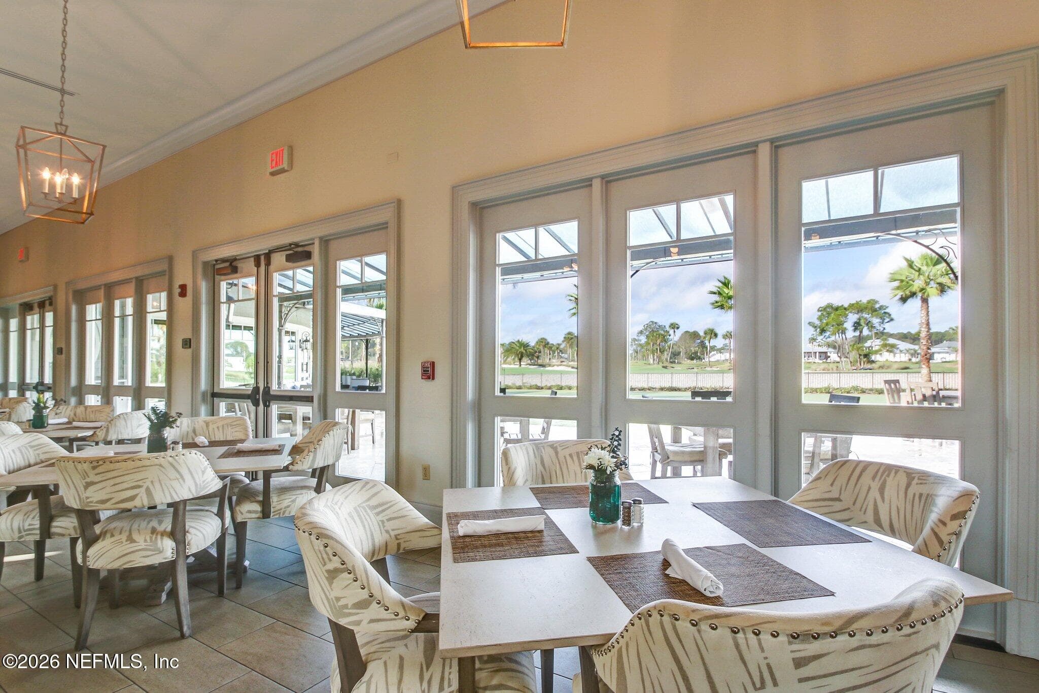 Club seating area with large windows and doors opening to outdoor views. — 568 TIMBER BRIDGE Lane, Atlantic Beach, FL 32233