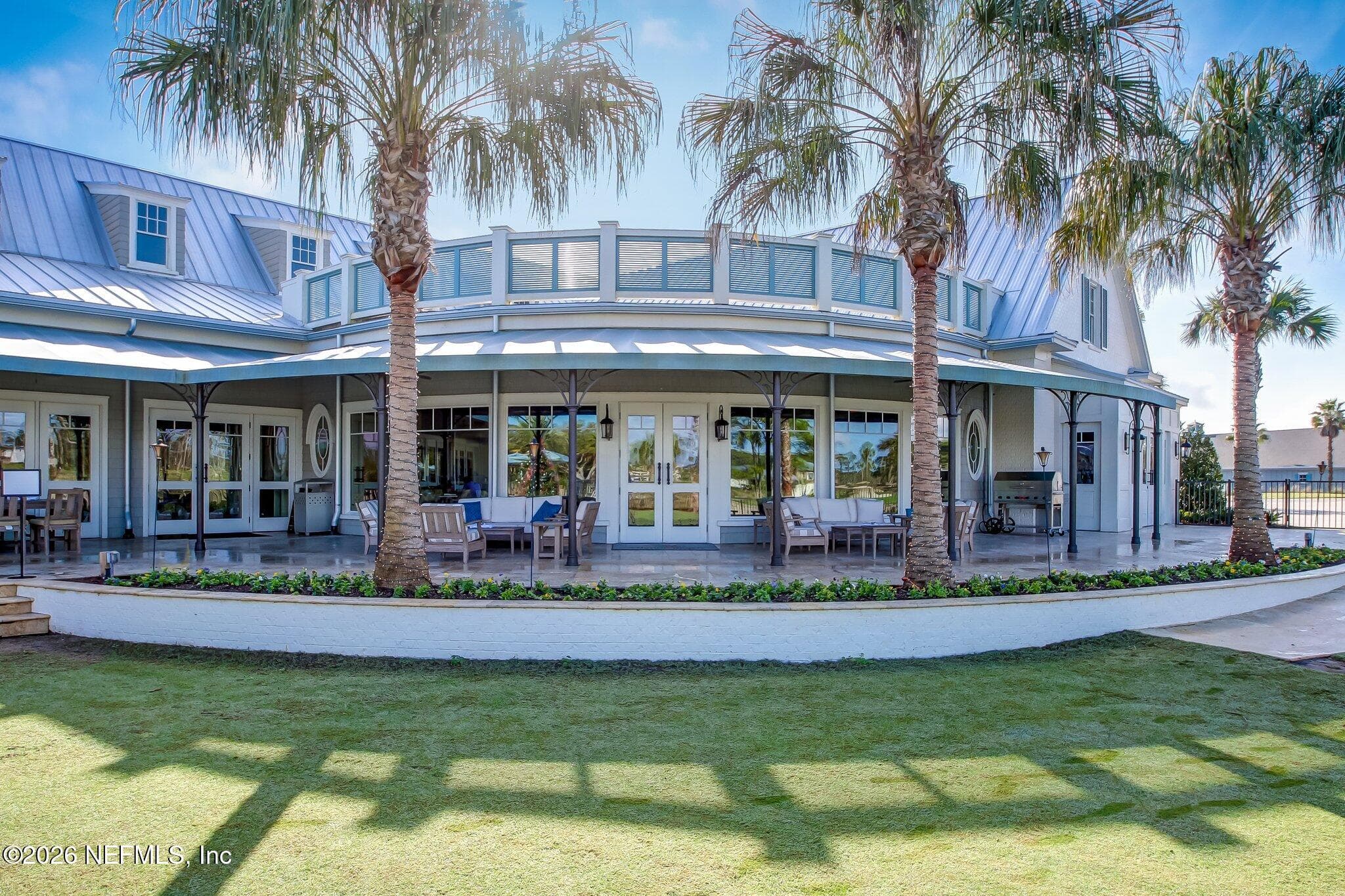 Clubhouse exterior framed by palm trees and landscaped grounds. — 568 TIMBER BRIDGE Lane, Atlantic Beach, FL 32233