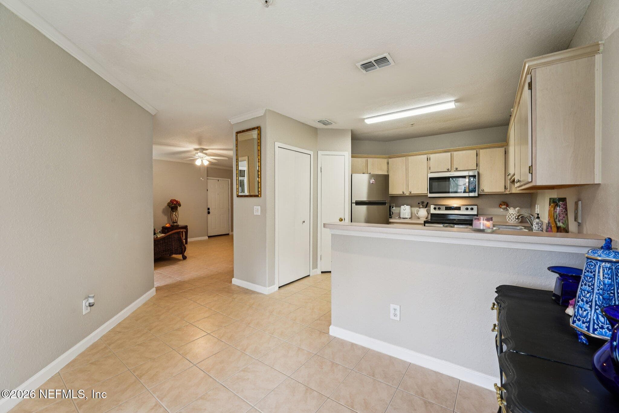 Dining room, view into the kitchen — 1701 THE GREENS Way 212, Jacksonville Beach, FL 32250