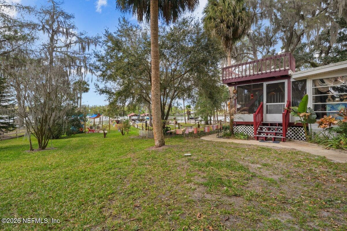Side yard looking towards back deck and water — 101 ORANGE Street, Satsuma, FL 32189