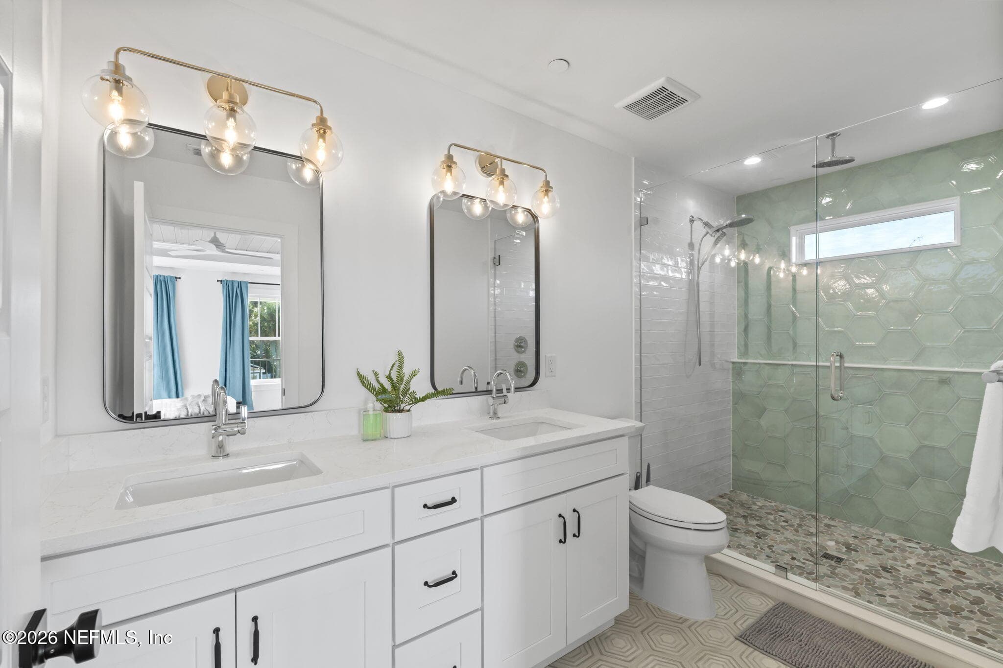 Primary bath with full heavy glass frameless shower enclosure, Schluter waterproofing system, upgraded Moen plumbing fixtures, adult-height vanities and quartz counters — 921 2ND Avenue S, Jacksonville Beach, FL 32250