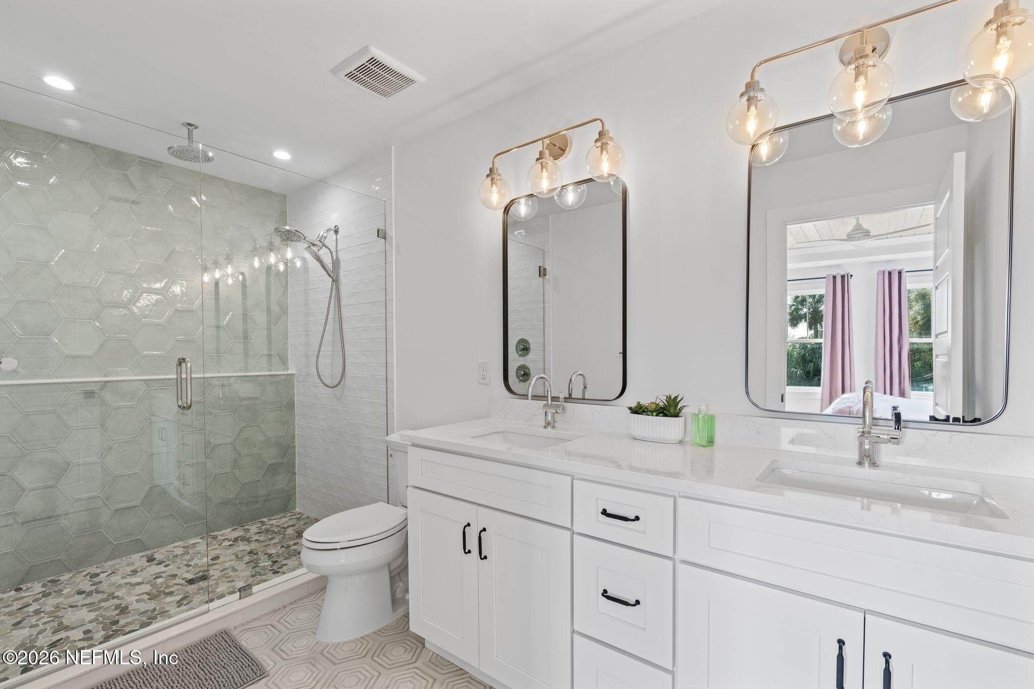 Primary bath with full heavy glass frameless shower enclosure, Schluter waterproofing system, upgraded Moen plumbing fixtures, adult-height vanities and quartz counters — 923 2ND Avenue S, Jacksonville Beach, FL 32250