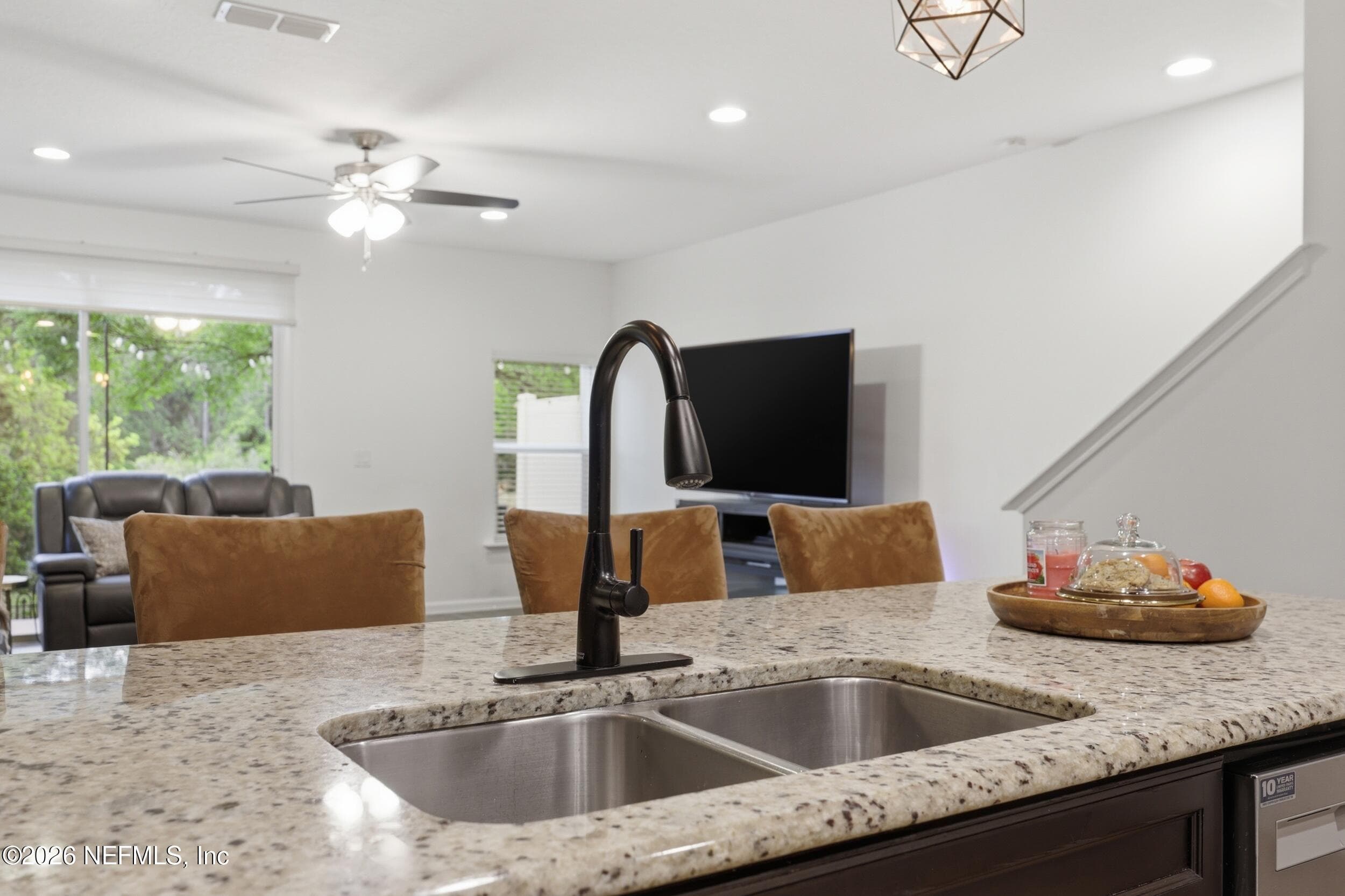 Close-up of the kitchen island featuring granite countertops and a modern faucet with clean finishes. — 3650 CRESWICK Circle C, Orange Park, FL 32065