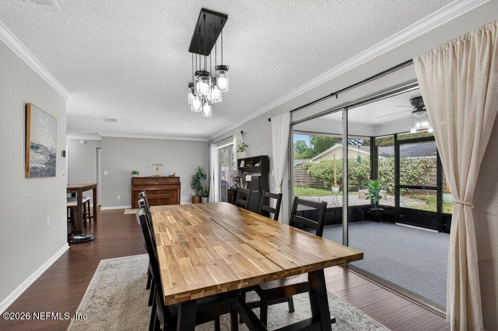 Versatile dining space highlighted by a contemporary light fixture and massive sliding glass doors that merge indoor and outdoor living. — 956 ESPINADO Avenue, St. Augustine, FL 32086