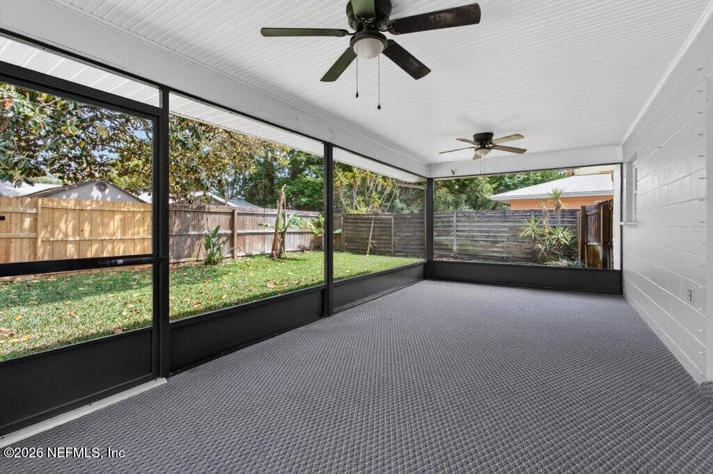 A large, fully screened-in lanai with dual ceiling fans and durable flooring, providing a comfortable transition between the indoors and the backyard. — 956 ESPINADO Avenue, St. Augustine, FL 32086