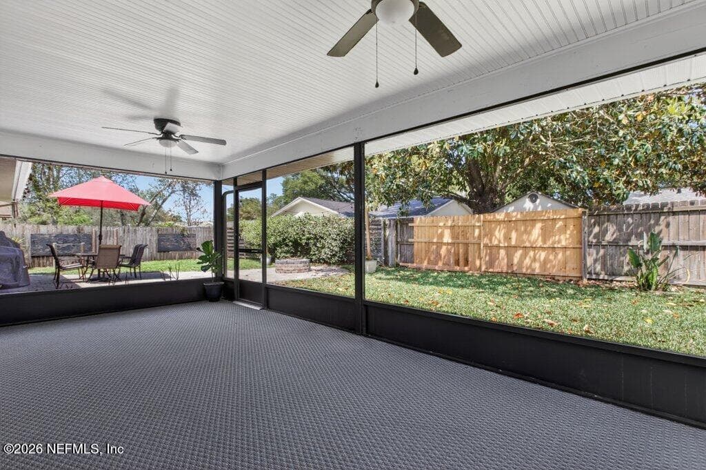 The screened enclosure provides a panoramic view of the private, fenced backyard, creating a secure and bug-free environment for relaxation. — 956 ESPINADO Avenue, St. Augustine, FL 32086