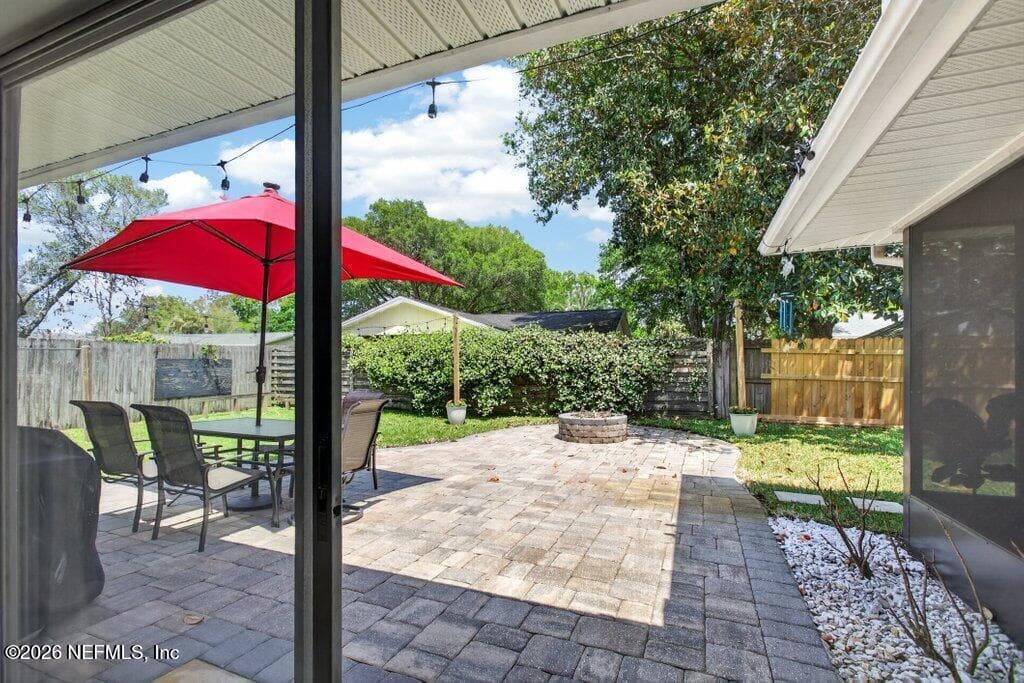 A sprawling paver patio designed for outdoor entertaining, featuring a built-in stone fire pit and plenty of open space for activities. — 956 ESPINADO Avenue, St. Augustine, FL 32086