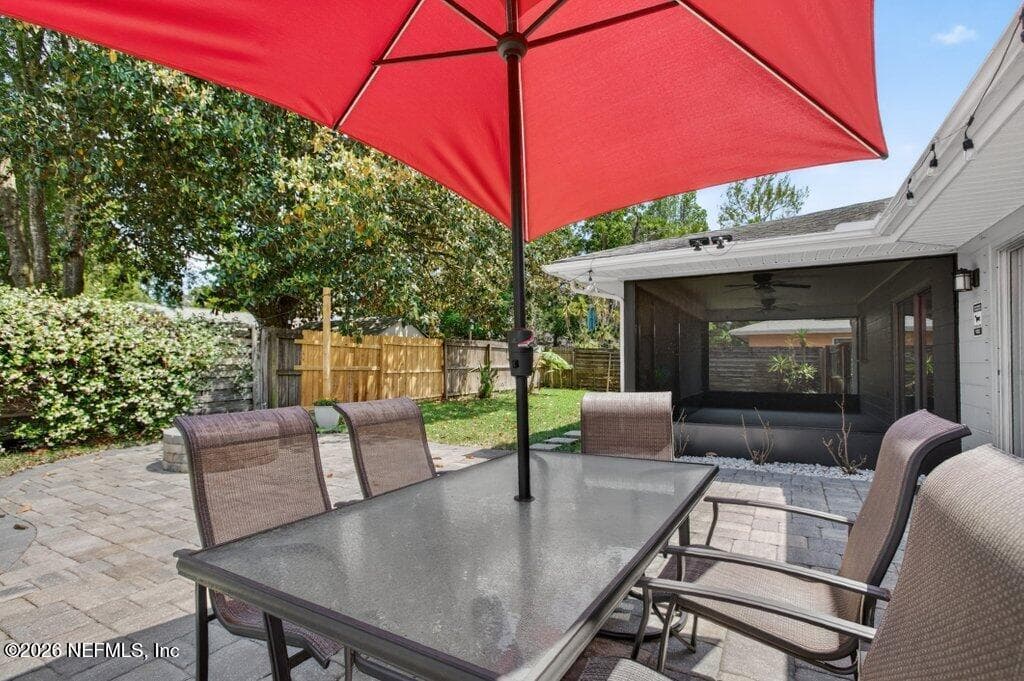 A closer look at the paved patio area, highlighting the versatile space available for alfresco dining adjacent to the screened enclosure. — 956 ESPINADO Avenue, St. Augustine, FL 32086