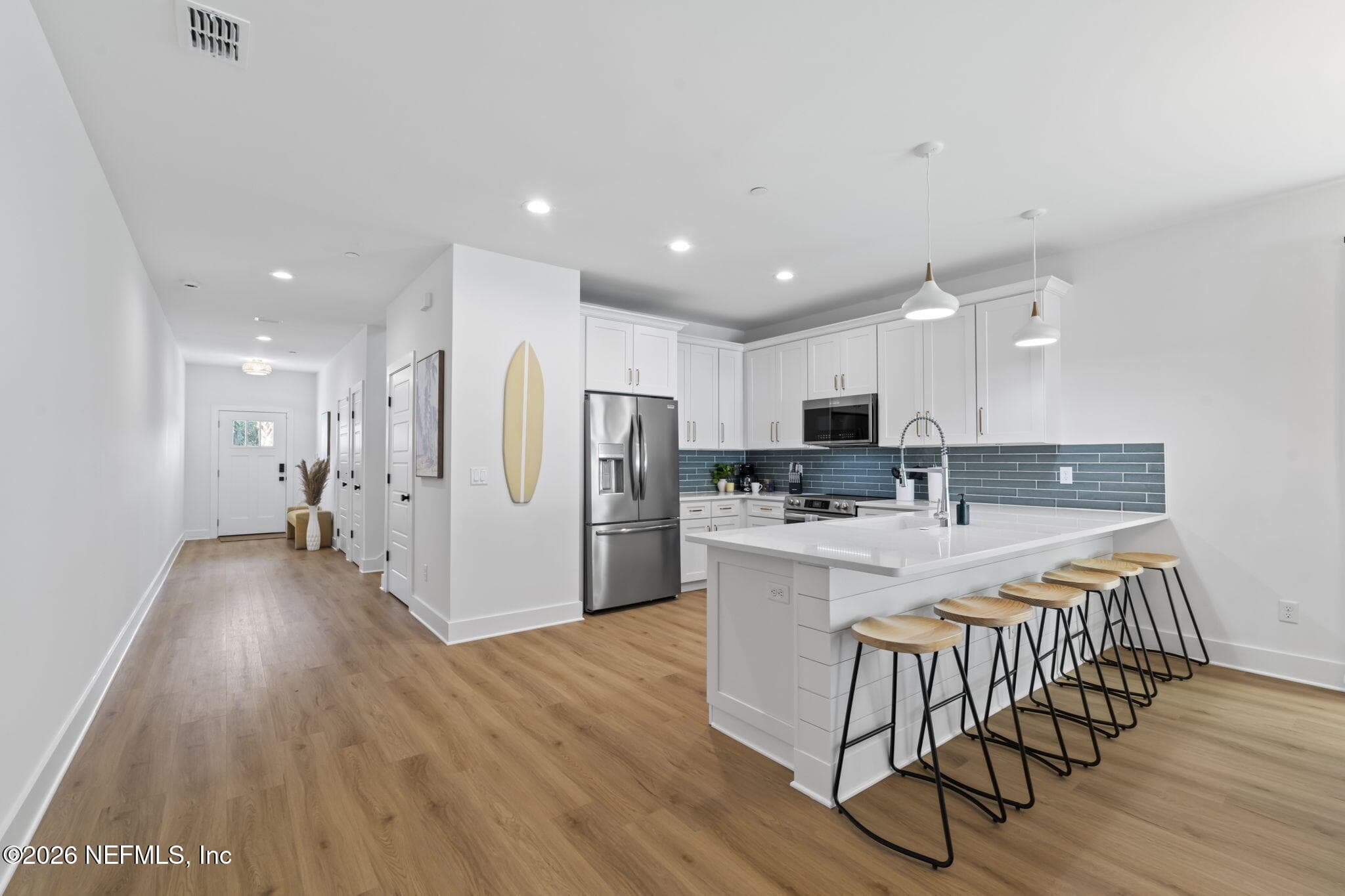 Kitchen: tiled backsplash, expansive counter depth bar seating, shiplap feature wall under bar top — 925 2ND Avenue S, Jacksonville Beach, FL 32250