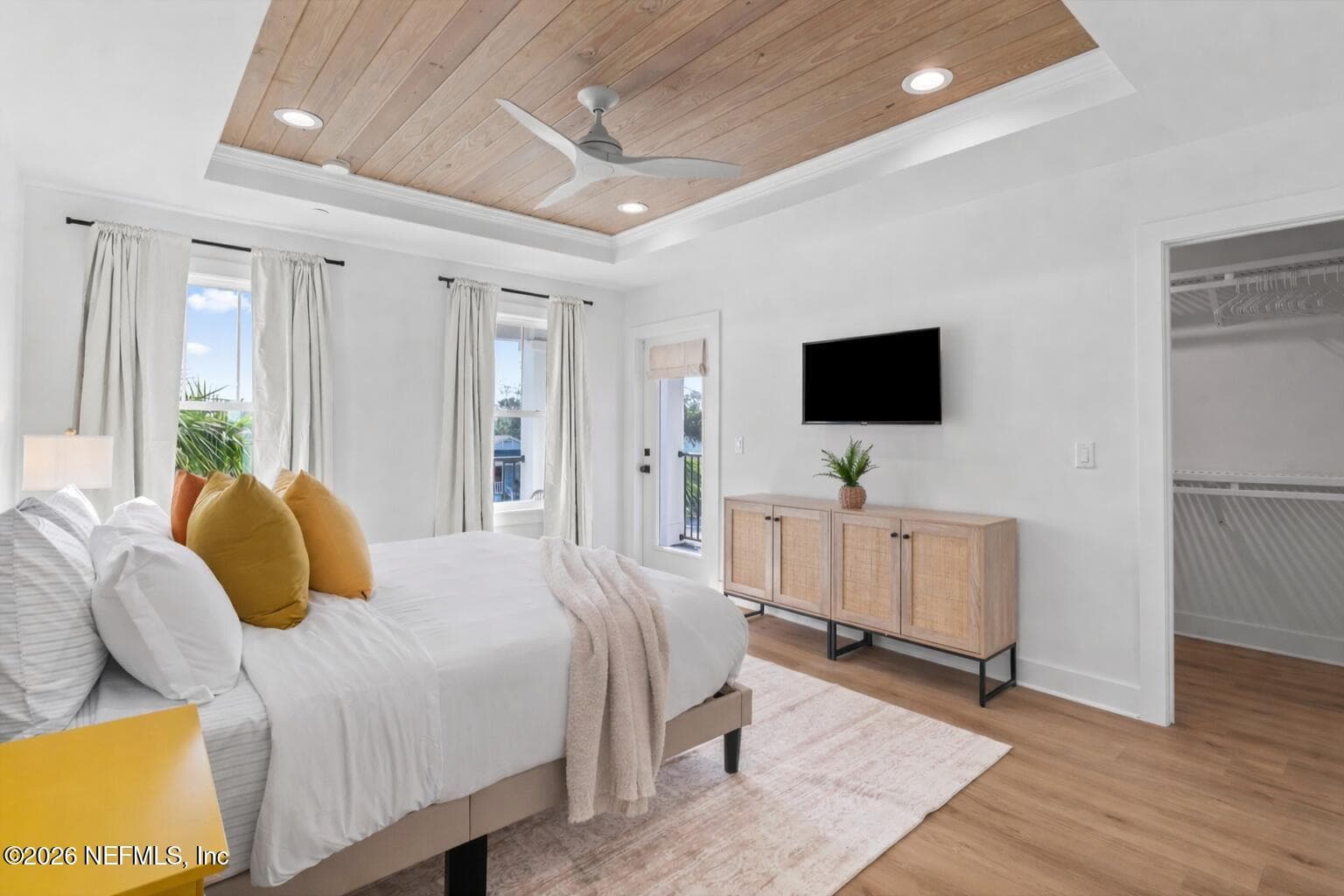Primary bedroom overlooking covered balcony with tongue and groove ceiling and ventilated wood shelving systems in ALL closets — 925 2ND Avenue S, Jacksonville Beach, FL 32250