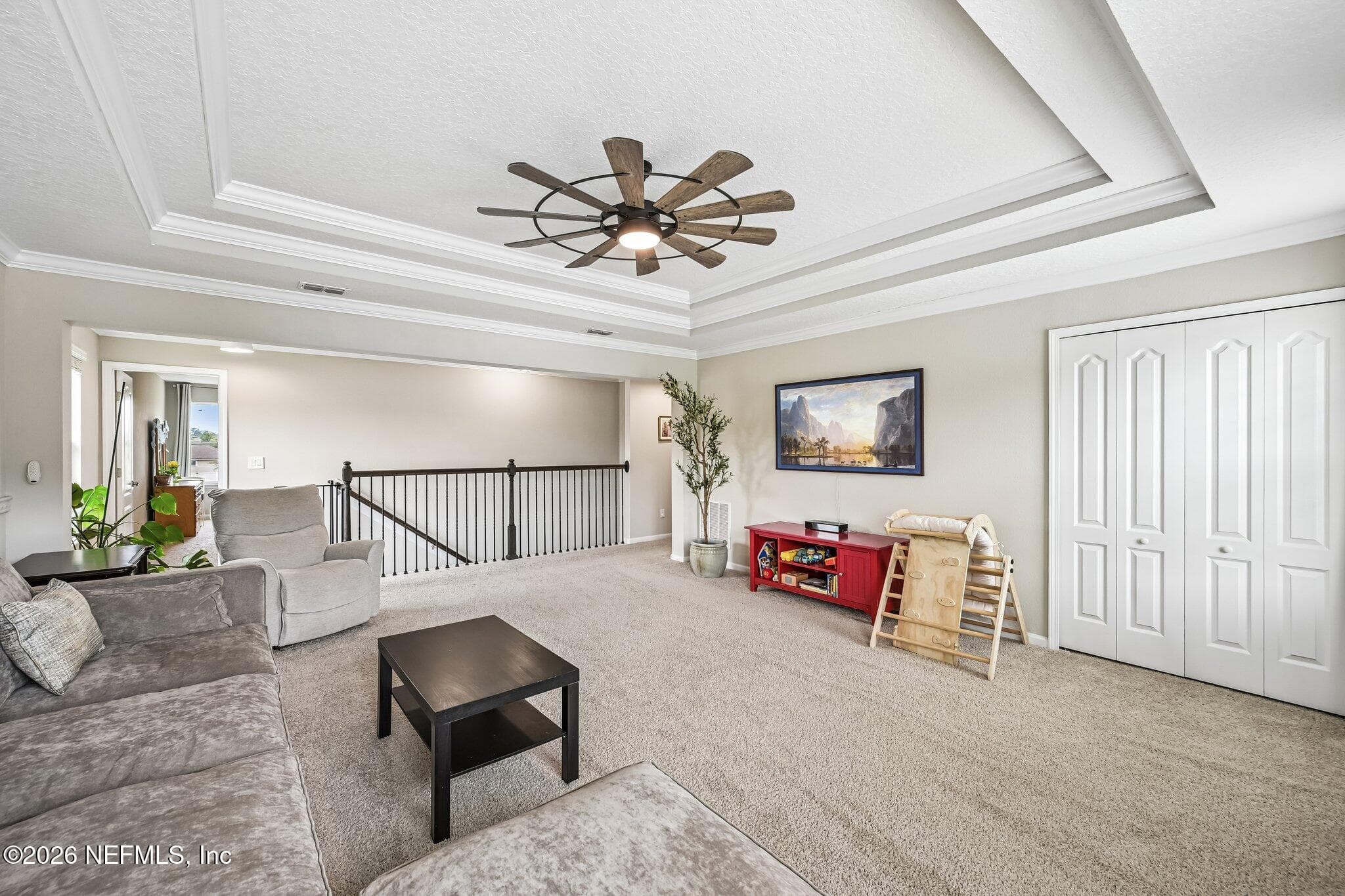 Large loft featuring tray ceilings and wainscoting, along with storage closet — 15694 CHIR PINE Drive, Jacksonville, FL 32218
