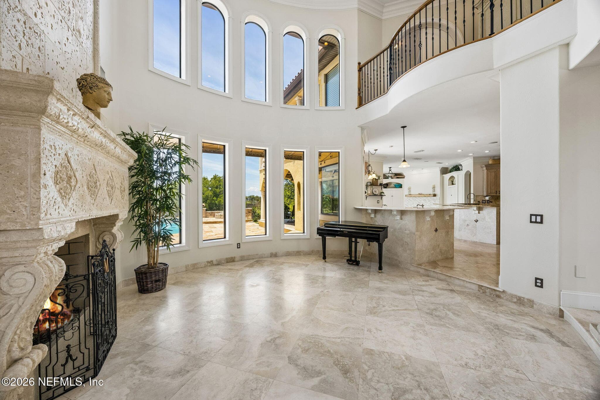 Soaring ceilings and expansive windows bring breathtaking views and abundant sunlight into this elegant living room, complete with a beautiful fireplace for added comfort and charm. — 430 ROYAL TERN Road S, Jacksonville Beach, FL 32250