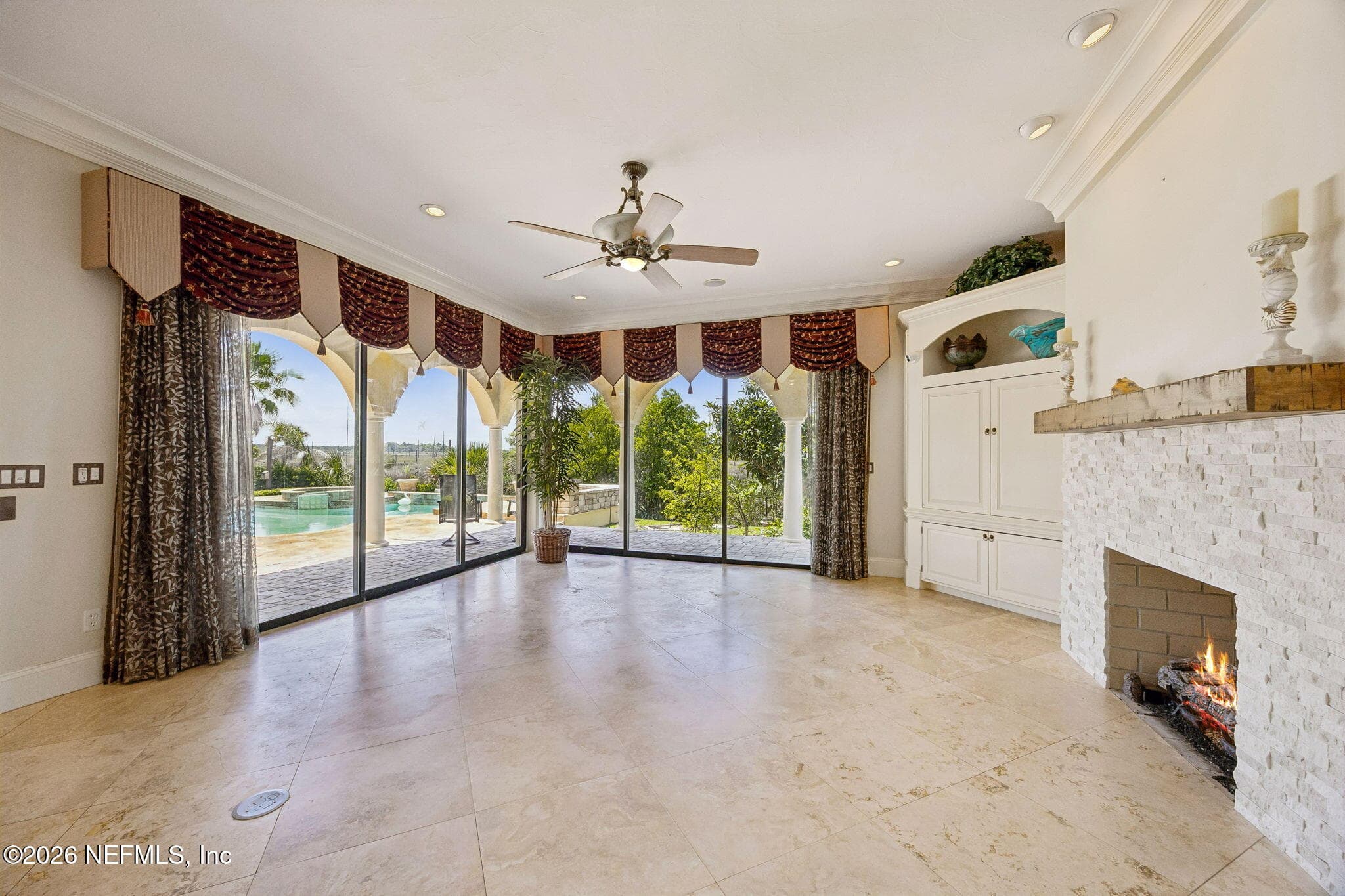 The family room offers a comfortable gathering space with abundant natural light, large windows framing the view, and a cozy fireplace that anchors the room. — 430 ROYAL TERN Road S, Jacksonville Beach, FL 32250