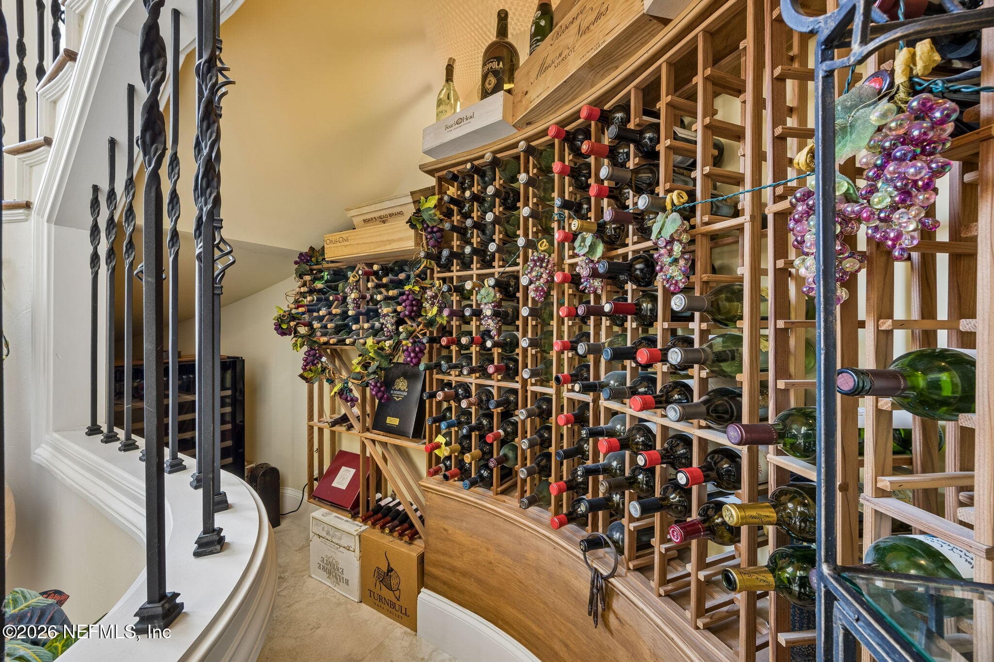 The home features a wine storage room with custom shelving and soft ambient lighting, creating an elegant space for preserving and displaying a curated collection. — 430 ROYAL TERN Road S, Jacksonville Beach, FL 32250