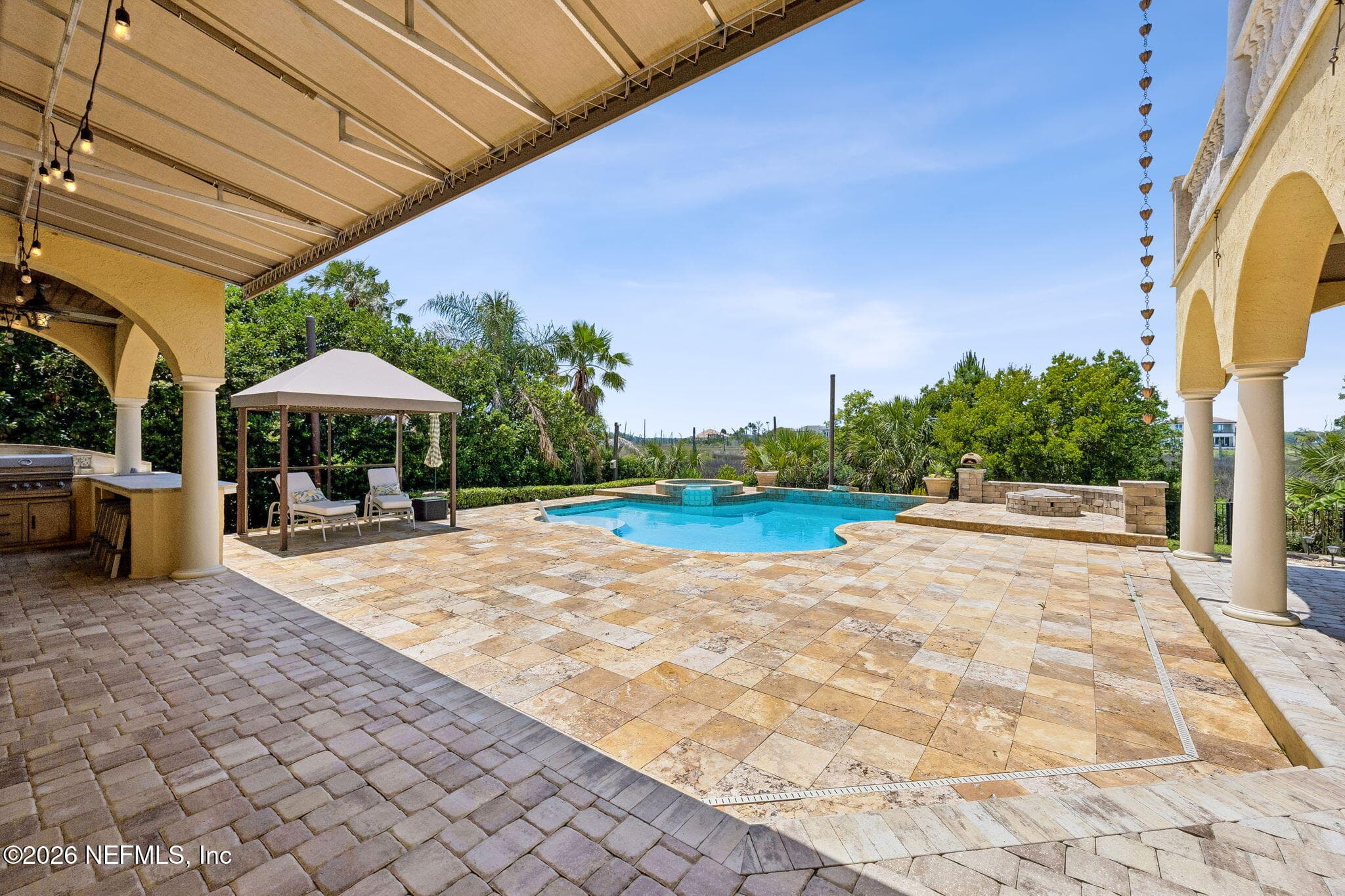The expansive outdoor space delivers a resort-like experience with a pristine pool, elegant hardscaping, and a seamless flow for indoor-outdoor living. — 430 ROYAL TERN Road S, Jacksonville Beach, FL 32250