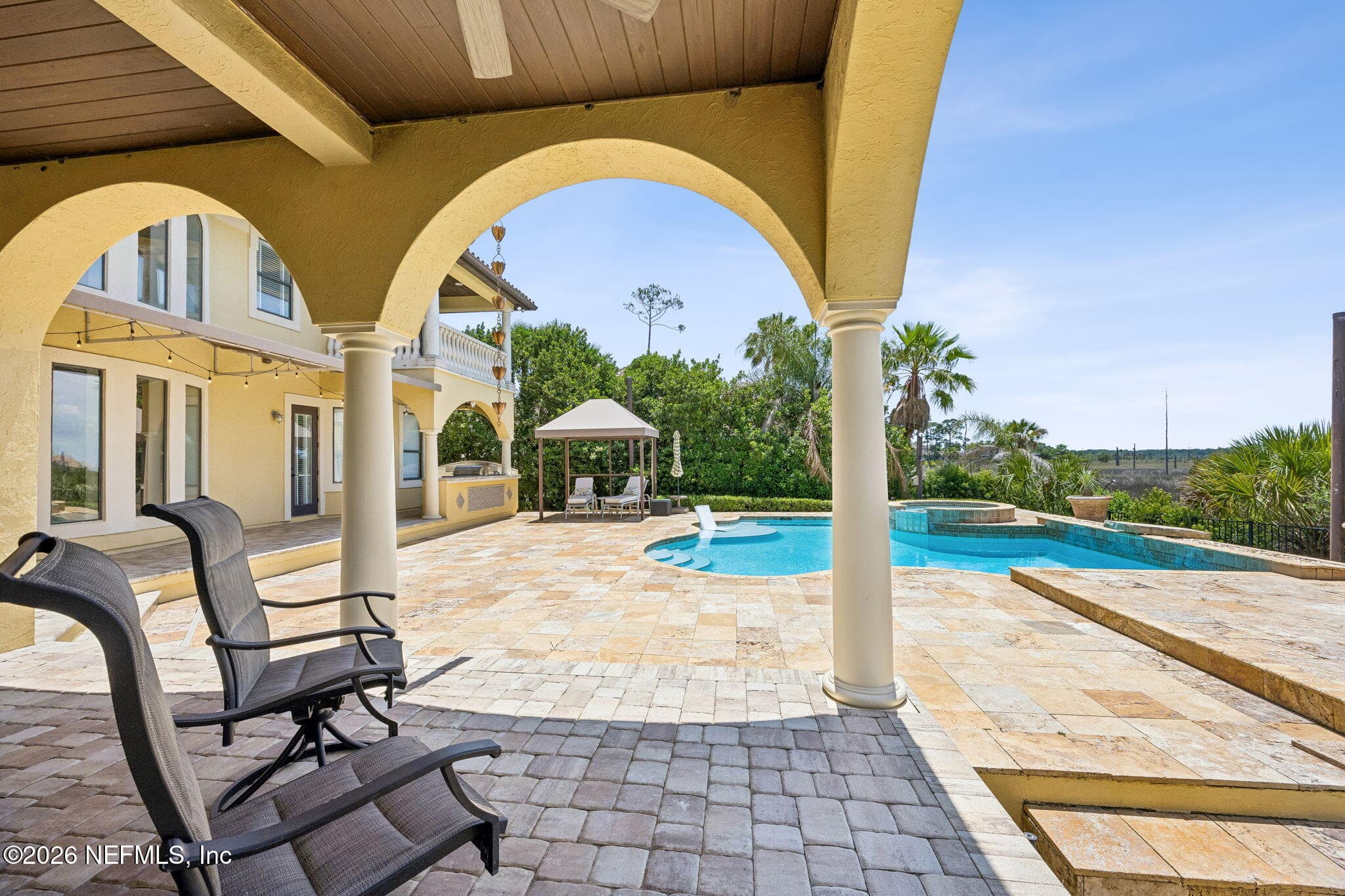 The backyard features a resort-style pool surrounded by lush greenery, with sweeping views of the marsh creating a peaceful natural backdrop. — 430 ROYAL TERN Road S, Jacksonville Beach, FL 32250