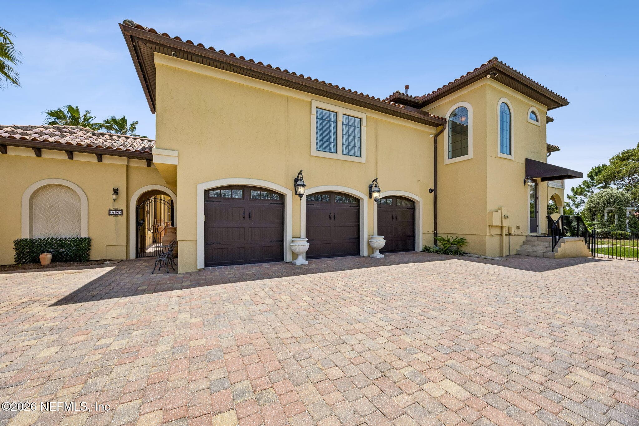 A generous three-car garage paired with a beautifully designed paver driveway provides both everyday convenience and striking curb appeal. — 430 ROYAL TERN Road S, Jacksonville Beach, FL 32250