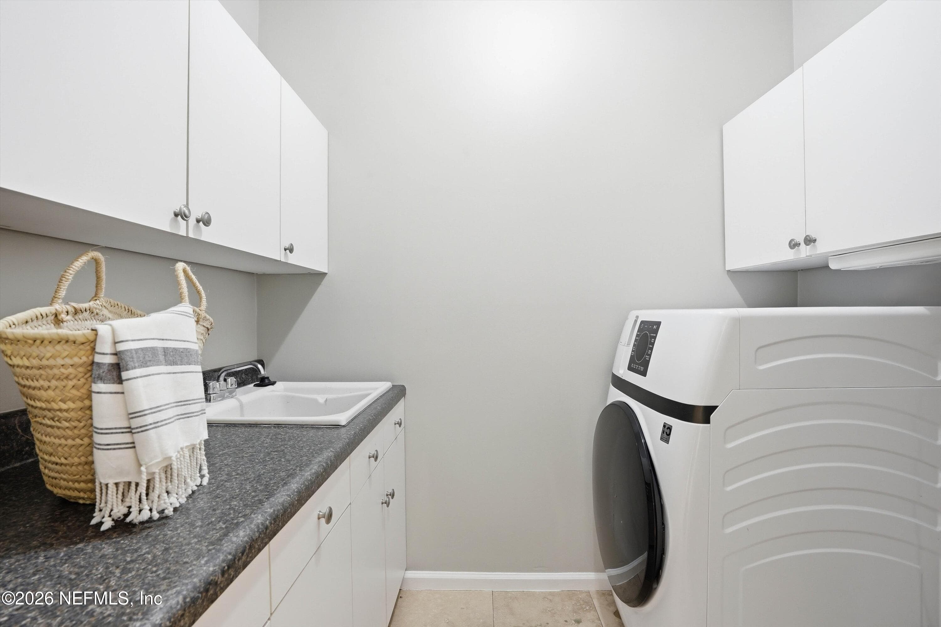 Laundry room complete with new washer/dryer combo, sink, tons of cabinetry and folding area. — 1817 SPICEBERRY Circle E, Jacksonville, FL 32246