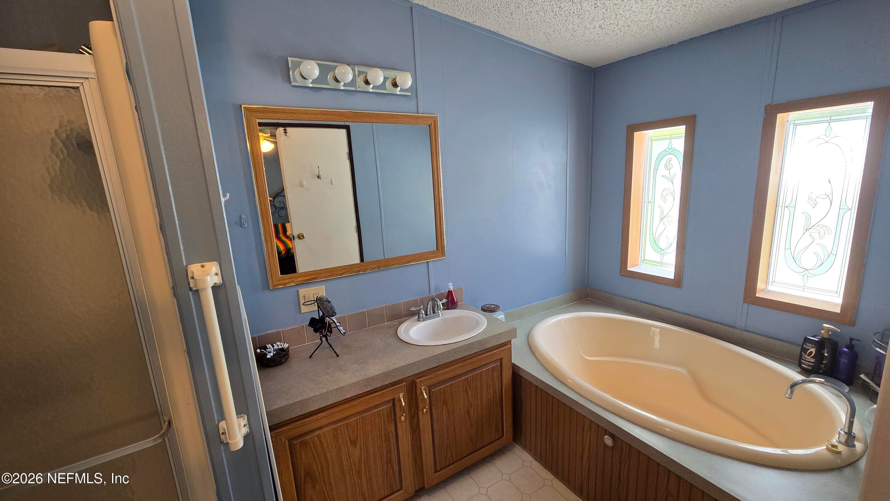 2204 Whippoorwill Dr, St Augustine, FL - large single sink vanity and garden tub in primary bathroom — 2204 WHIPPOORWILL Drive, St. Augustine, FL 32084