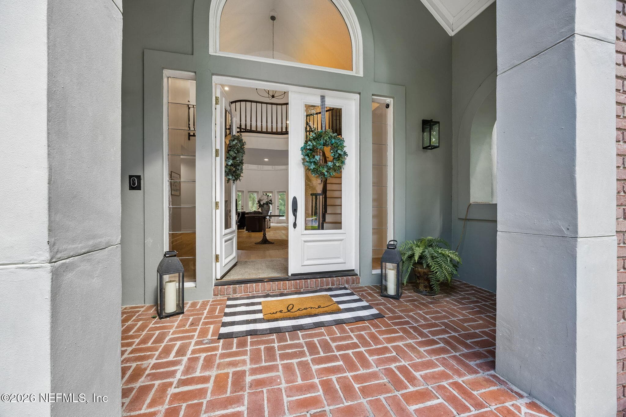 Step through the grand covered entry into a welcoming foyer featuring elegant double doors, soaring ceilings, and timeless architectural detail. — 5070 BENTGRASS Circle, Ponte Vedra Beach, FL 32082