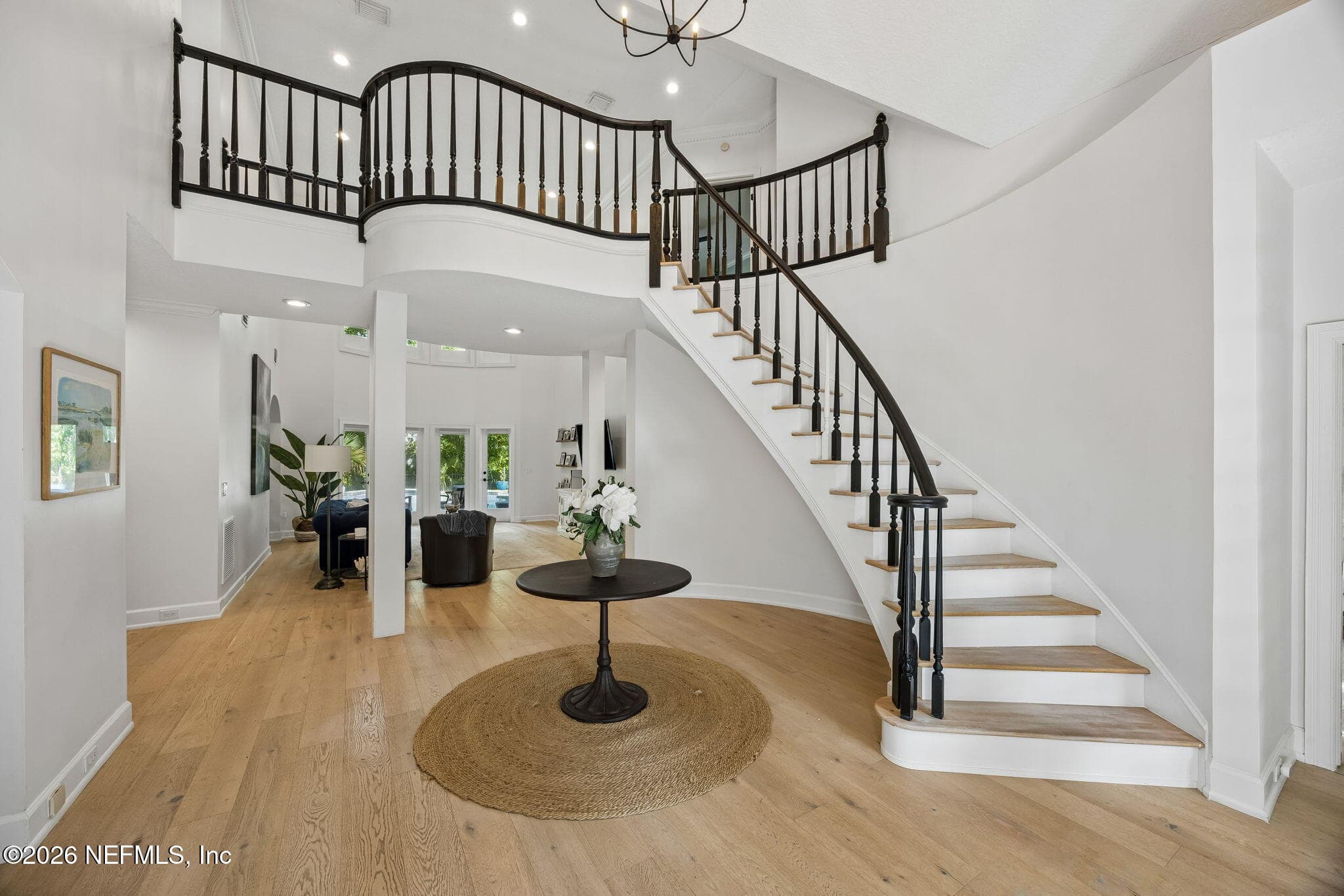 A stunning double-height foyer welcomes you with a sweeping staircase, hardwood floors, and an abundance of natural light, creating an elegant first impression. — 5070 BENTGRASS Circle, Ponte Vedra Beach, FL 32082