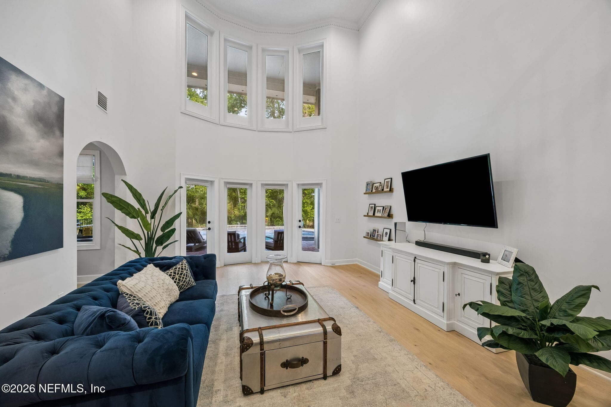 Soaring ceilings and dramatic floor-to-ceiling windows flood the living room with natural light while showcasing peaceful backyard views. — 5070 BENTGRASS Circle, Ponte Vedra Beach, FL 32082