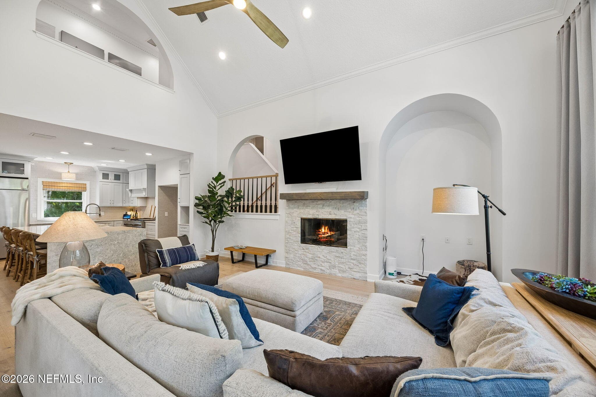 A stunning stone fireplace, oversized windows, and vaulted ceilings create a warm yet sophisticated gathering space. — 5070 BENTGRASS Circle, Ponte Vedra Beach, FL 32082