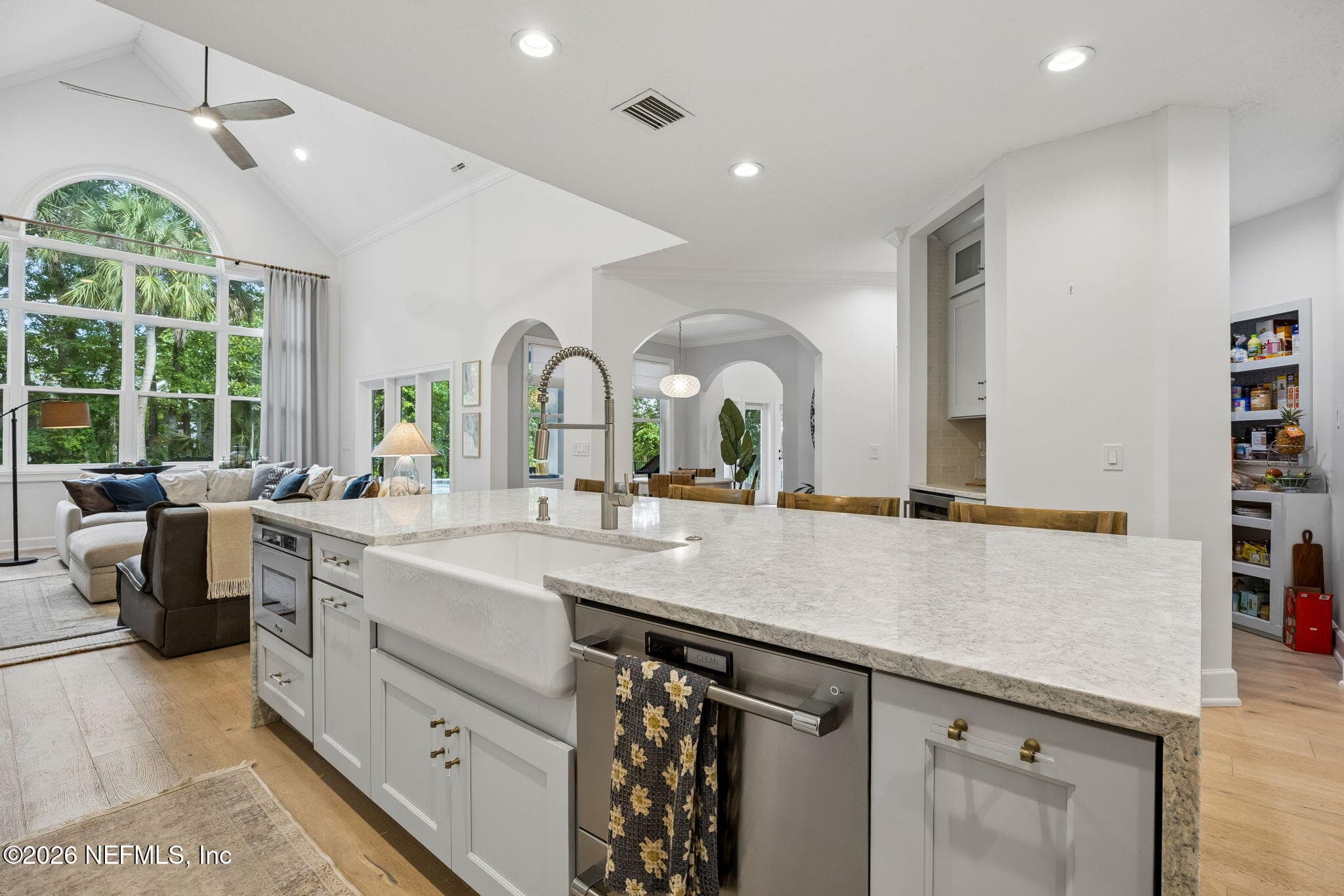 The expansive quartz island with farmhouse sink anchors the kitchen, offering ample seating and seamless flow into the living spaces. — 5070 BENTGRASS Circle, Ponte Vedra Beach, FL 32082