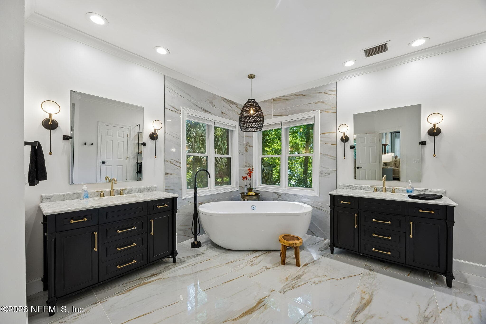 Luxurious spa-inspired bathroom featuring dual vanities, porcelain tile, and a freestanding soaking tub. — 5070 BENTGRASS Circle, Ponte Vedra Beach, FL 32082