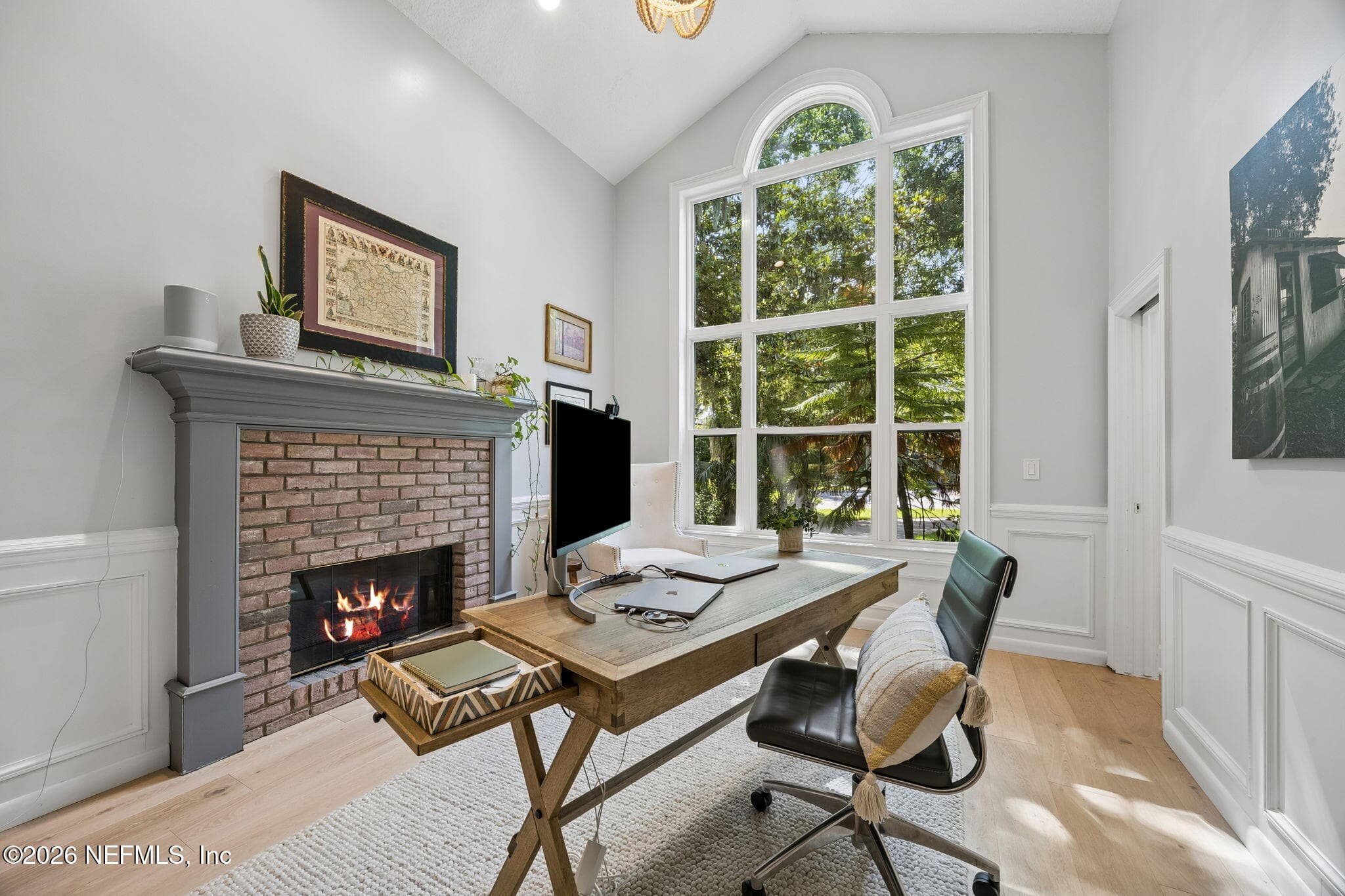 Elegant home office with soaring ceilings, a classic brick fireplace, and oversized windows overlooking lush greenery. — 5070 BENTGRASS Circle, Ponte Vedra Beach, FL 32082