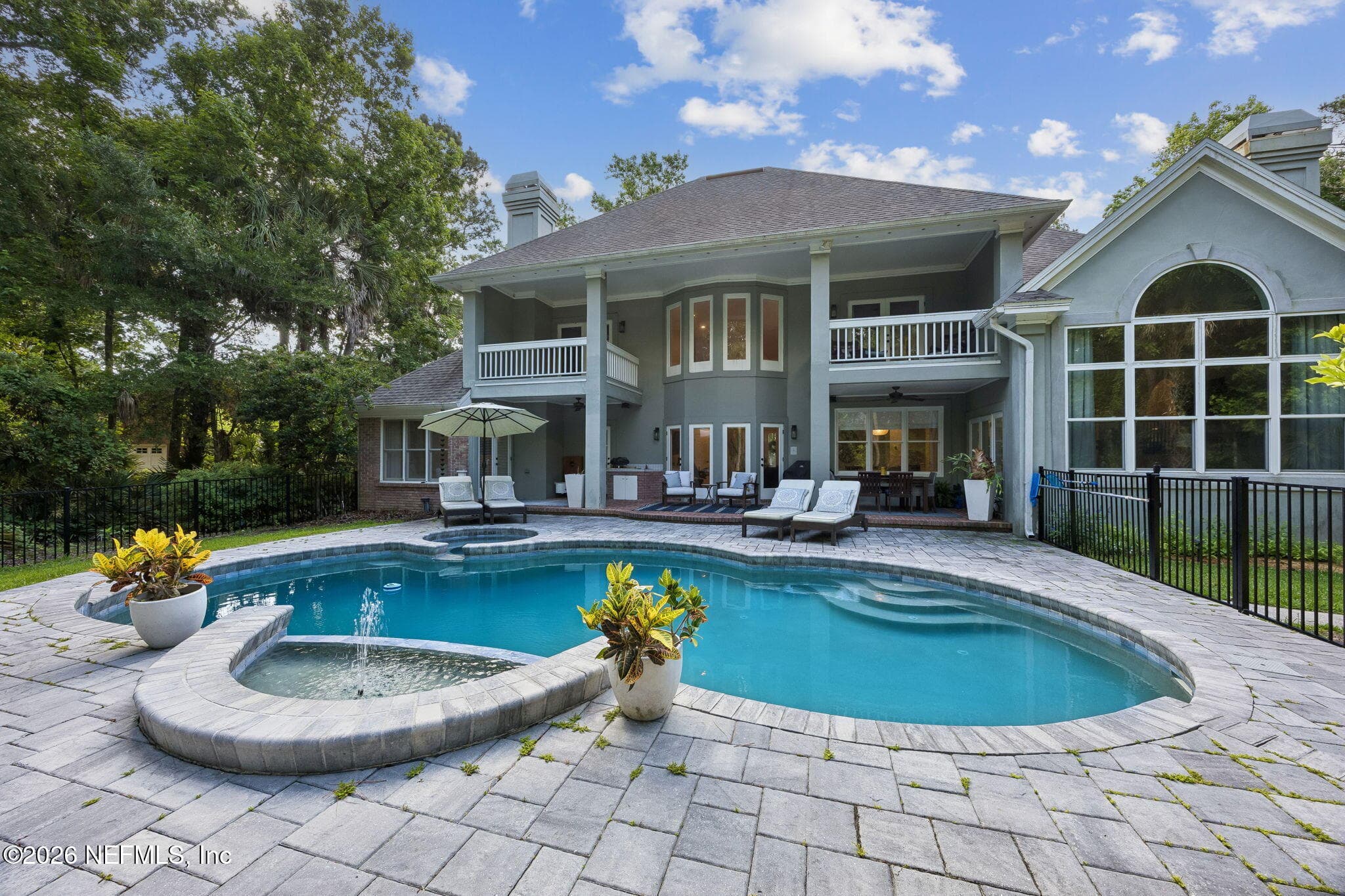 Private backyard retreat with a resort-style pool and spa, expansive covered lanai, and lush wooded surroundings. — 5070 BENTGRASS Circle, Ponte Vedra Beach, FL 32082